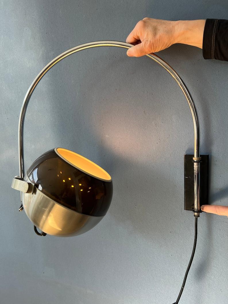 A very rare space age arc wall lamp by Dijkstra called 'The Globe'. The transparent outer shade and aluminium inner shade produce a magnificent light together. The shade can be turned in any direction desirable and moved inside or outside the arc.