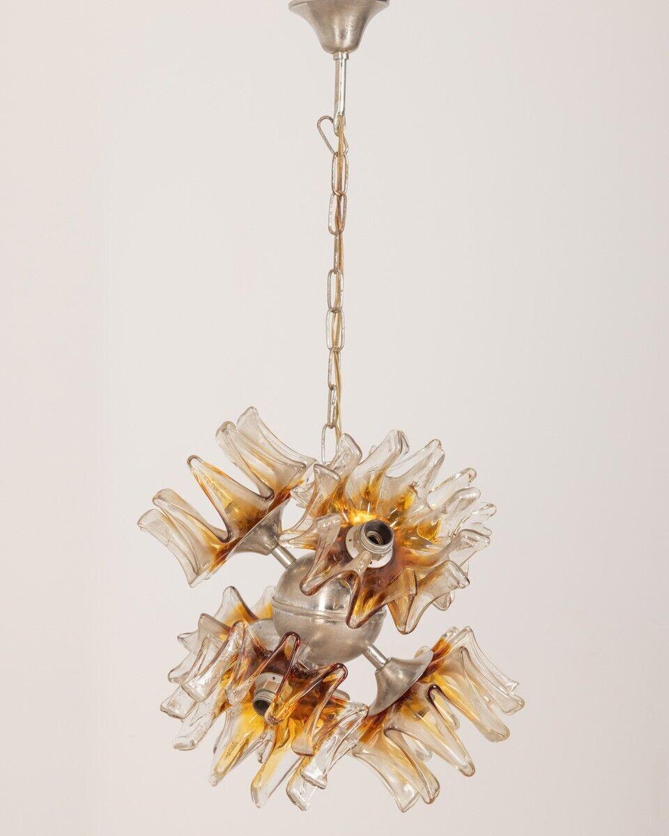 Six-light chandelier with Murano glass lampshades, Sputnick model, 1970s.

Conditions: In good condition, working, it may show signs of wear due to time.

Dimensions: Height 69 cm; Diameter 35 cm

Materials: Metal and Glass

Year of