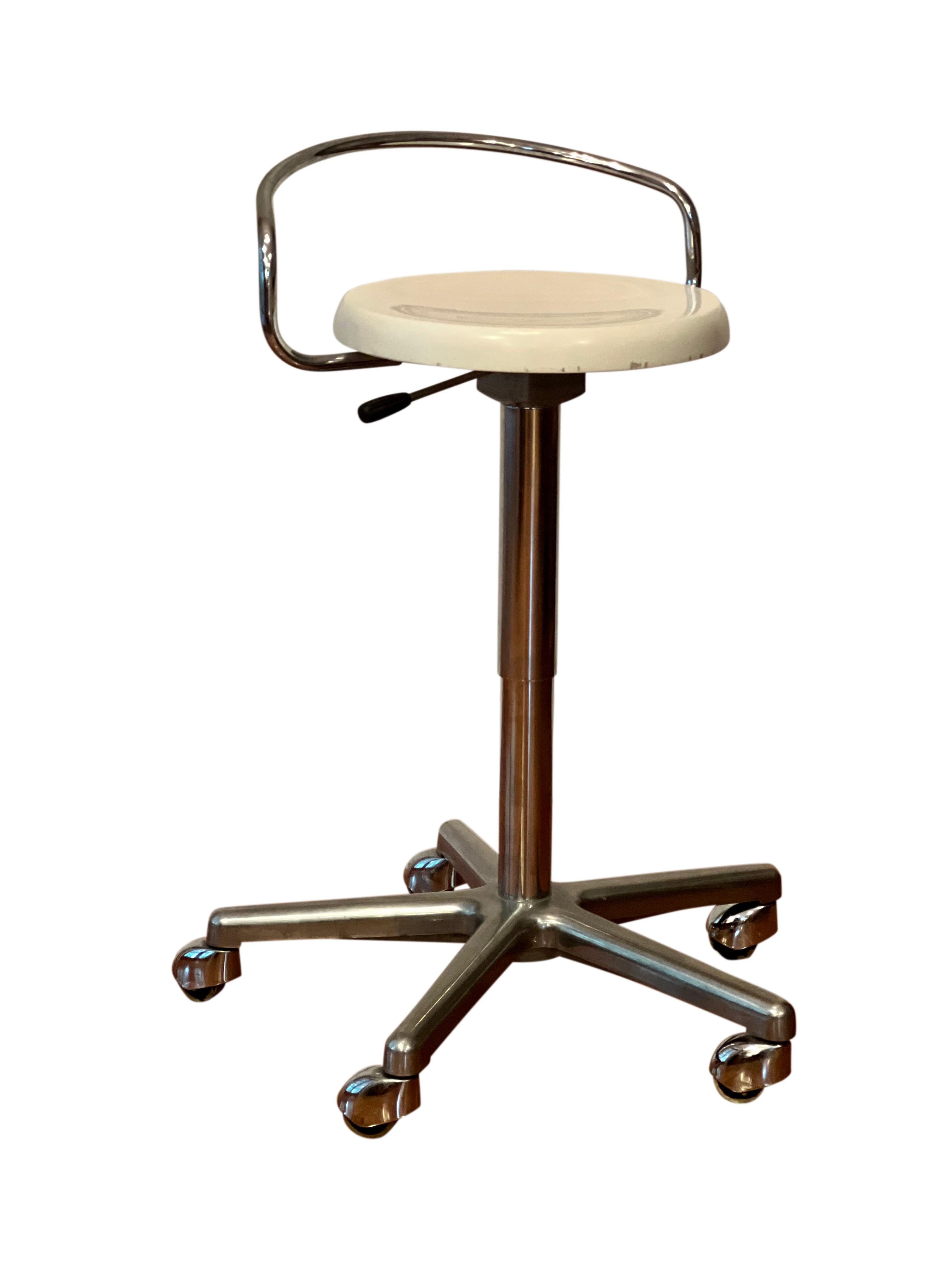 1970's swivel adjustable height rolling work stool.

Features a white lacquered wood seat with curved backrest on a shiny chrome base.  The seat swivels 360 degrees and adjusts from chair to bar height, 19.5