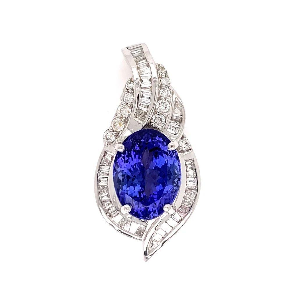 Simply Beautiful! Elegant an Finely detailed Show Stopper Tanzanite Gemstone and Diamond Statement Gold Pendant on Platinum Chain Necklace. Centering a securely nestled Hand set 7.35 Carat Oval Tanzanite. Surrounded by Hand set Diamonds, weighing