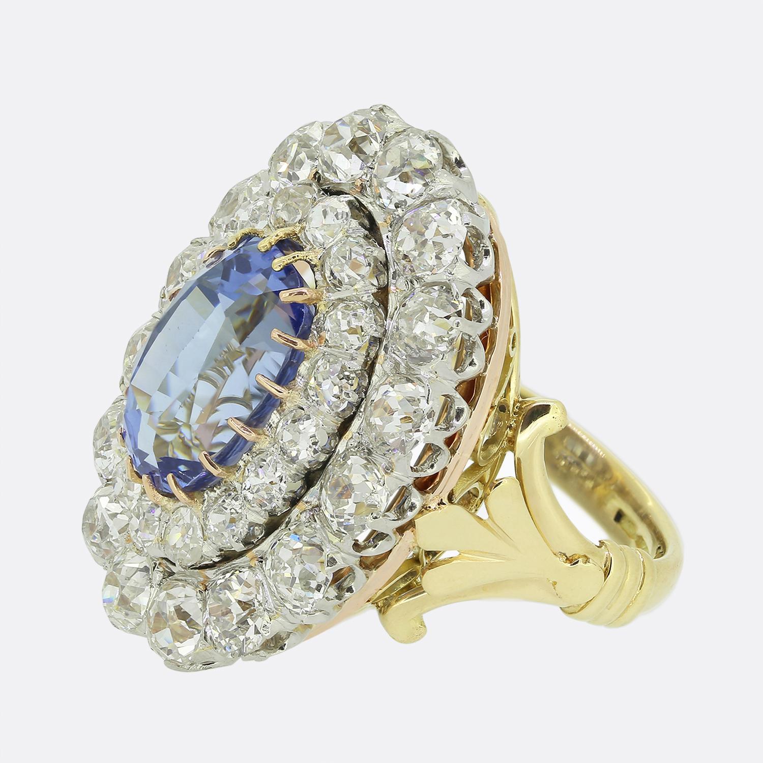 Here we have a marvellous sapphire and diamond cluster dress ring. This vintage piece has been crafted from a warm 18ct yellow gold and features a single oval faceted Ceylon sapphire possessing a natural cornflower blue colour tone. This enchanting