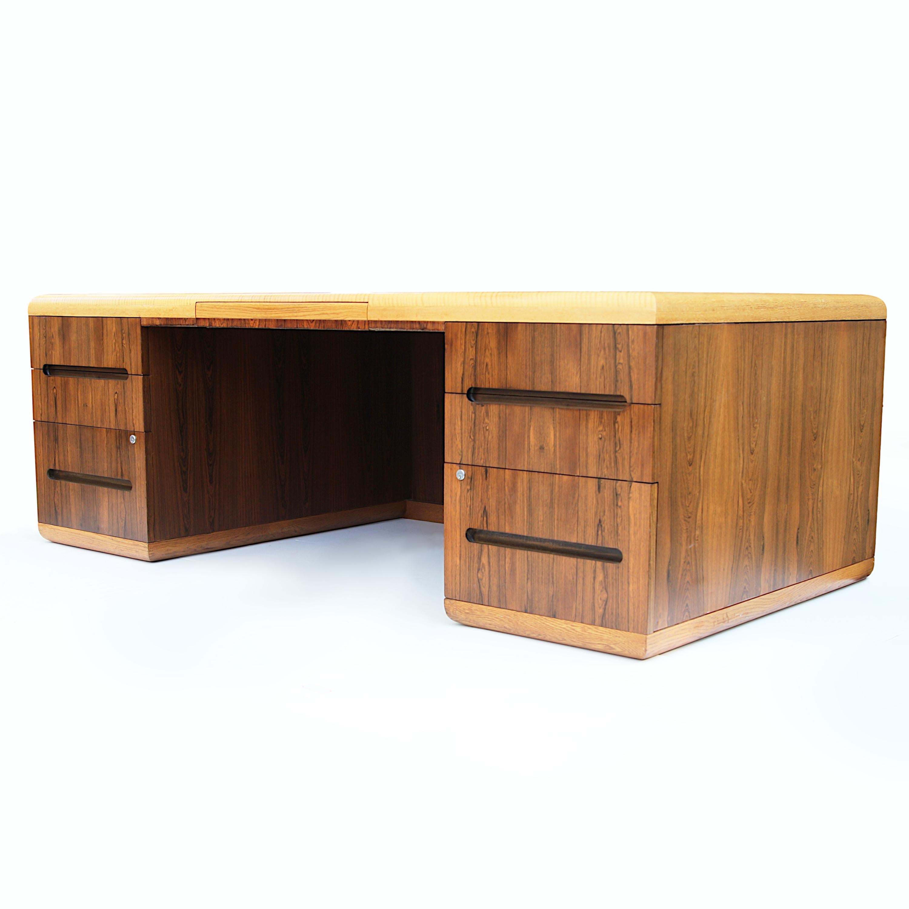 This beautifully-made executive desk features a design reminiscent of Roger Sprunger  and the unparalleled build-quality for which Dunbar is renowned. The clean, Minimalist lines are complemented by the contrasting oak and rosewood veneers. With its