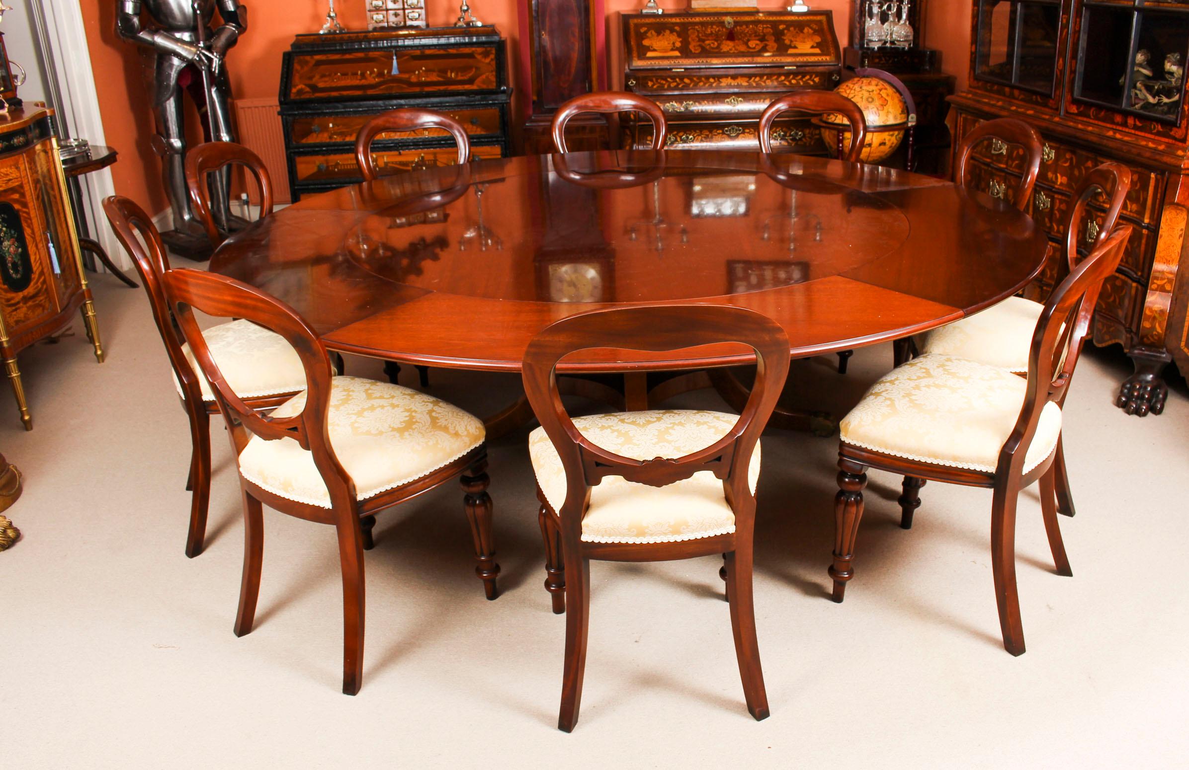 This is a gorgeous Regency revival Jupe style flame mahogany dining table by the master cabinet maker William Tillman, circa 1970 in date.
 
The table has a solid mahogany top that has five additional perimeter leaves that can be added around the