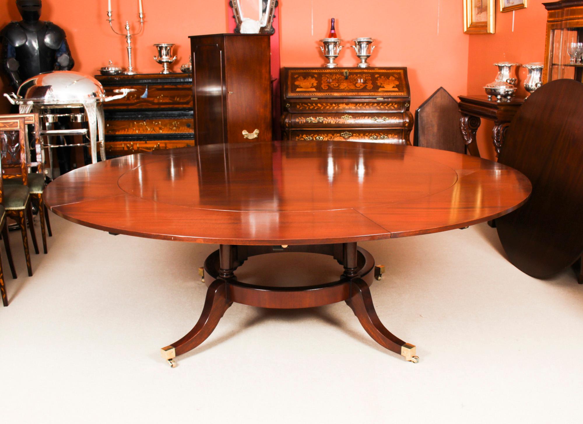 This beautiful dining set comprises a Regency Revival Jupe style dining set comprising a dining table, a leaf cabinet, a Lazy Susan and the matching set of ten Vintage Swag Back dining chairs, mid 20th Century in date.

The table has a solid