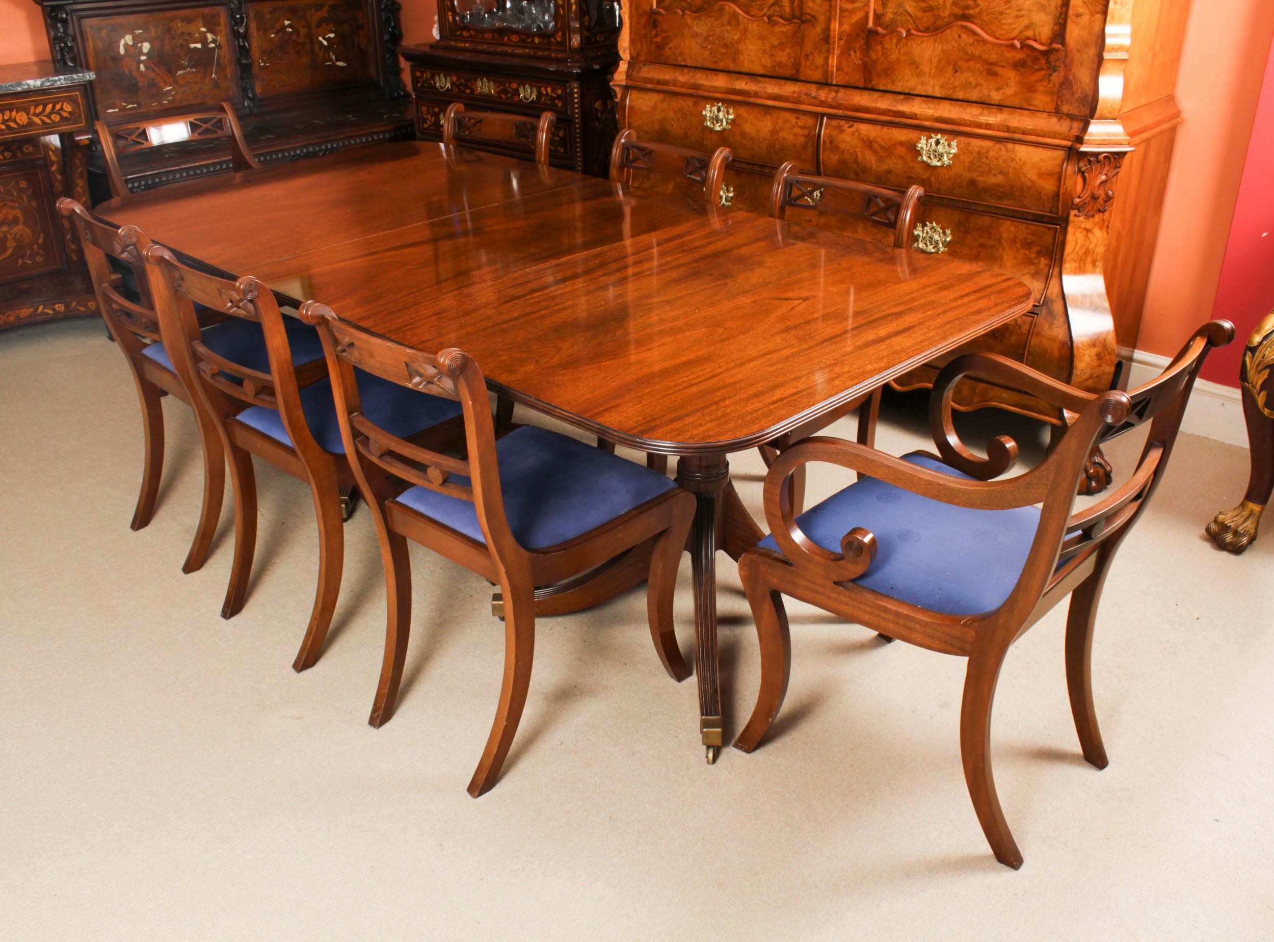 This is  a fabulous Vintage Regency Revival twin pillar dining table Hand Crafted by Mines of Downley, Buckinghamshire, England, dating from the mid 20th Century.

The table is made of stunning solid flame mahogany and is raised on twin 