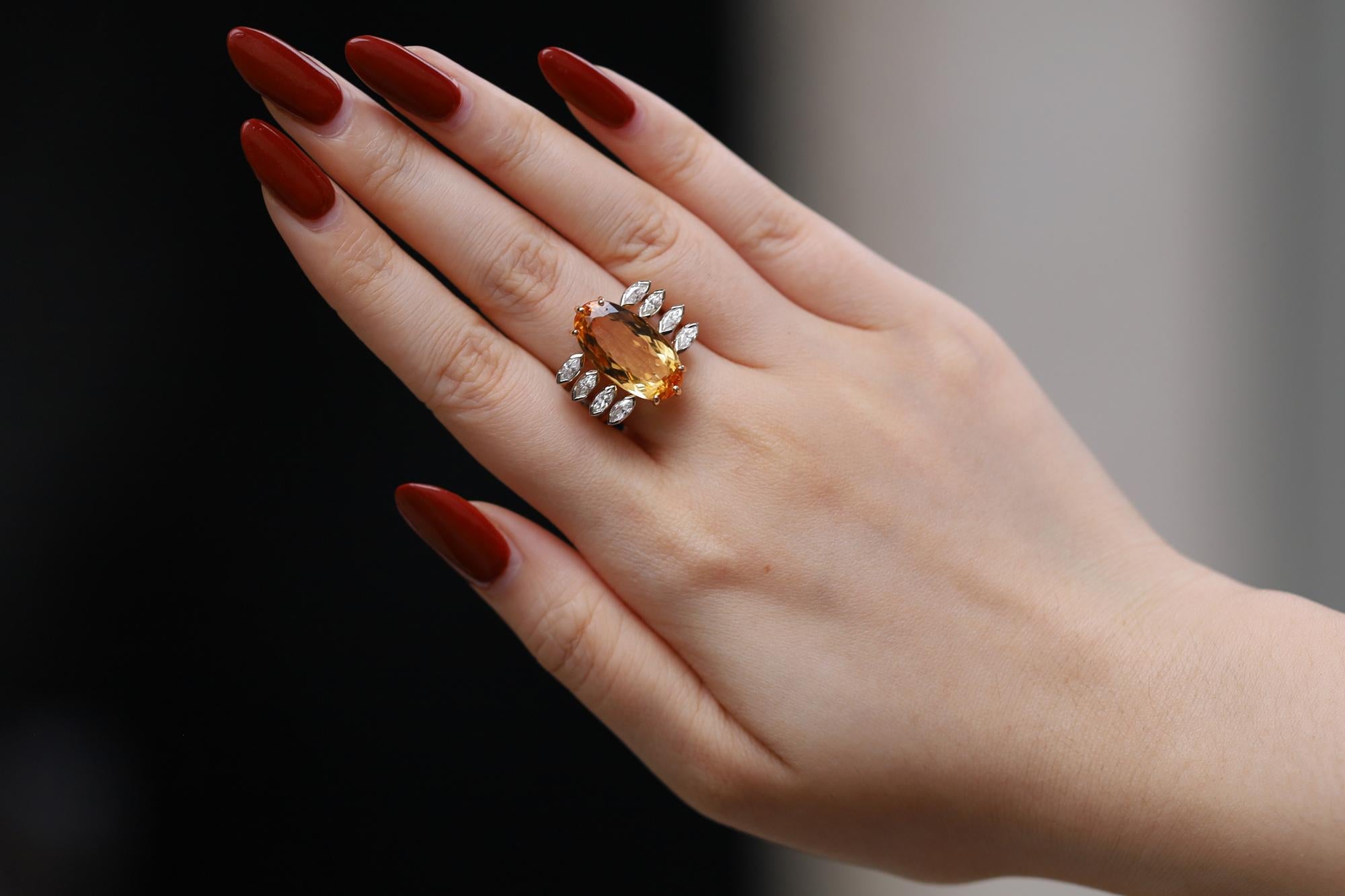 A contemporary cocktail ring, emblematic of your favorite Retro era Hollywood glam talents. The focal point of this stunning ring is an 8.85 carat natural Imperial Topaz, precisely cut into an impressive elongated oval. Crafted in 14k yellow and