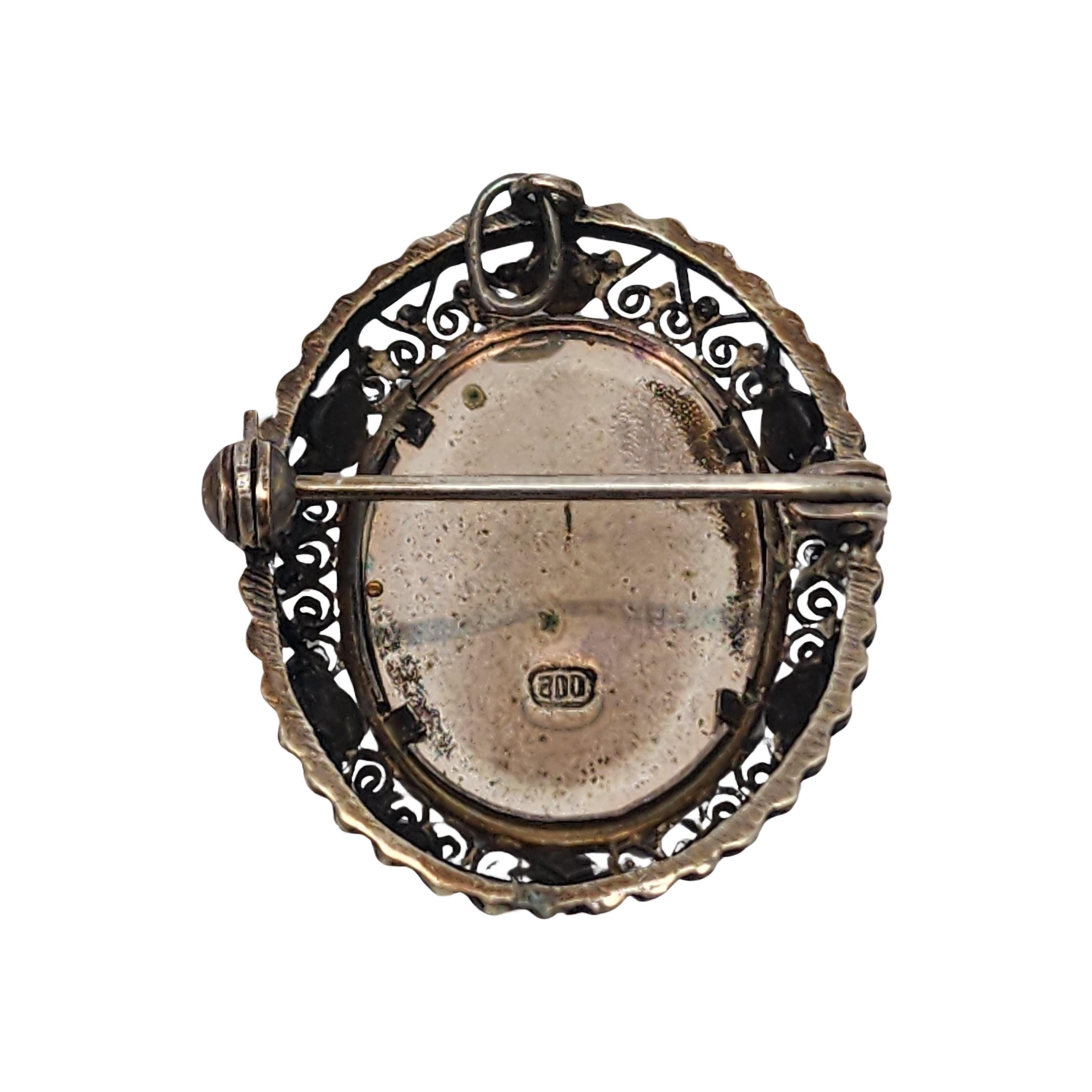 Vintage 800 silver painted lady pendant/pin/brooch.

A beautifully painted lady cameo set in a silver filigree frame with red bead accents. Can be worn as a pendant or a pin.

Measures approx 1 1/4