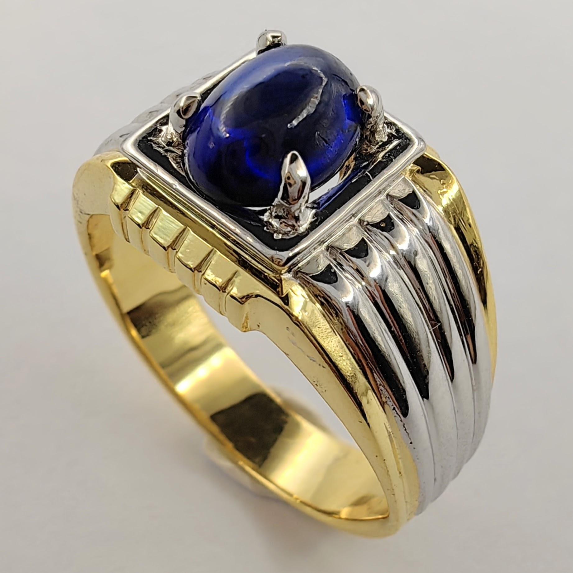 Introducing our Vintage 80's 1.66 Carat Cabochon Sapphire Two-Tone Men's Ring in 18K Gold, a timeless piece that combines classic elegance with a touch of retro charm, enriched with exquisite details.

At the heart of this distinguished ring lies a