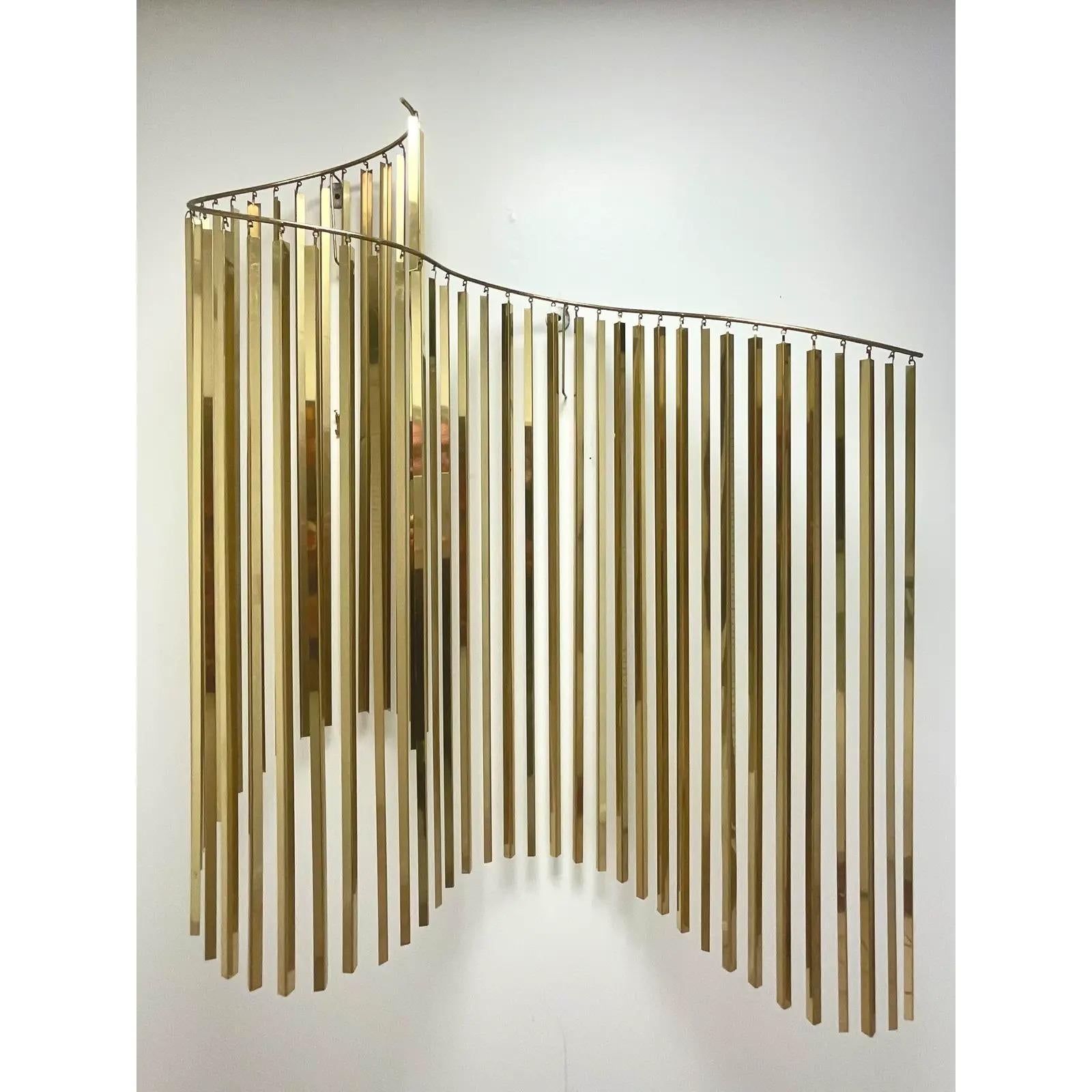 Fantastic vintage 80s brass wall sculpture. Done in the manner of Curtis Jere. Beautiful brass blades suspended from a rolling bar. Acquired from a Palm Beach estate.