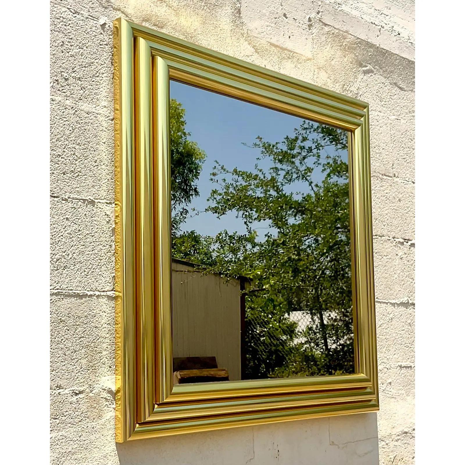 A fantastic vintage 80s wall mirror. Made by the iconic Greg Copeland group. A polished brass series of rods in a descending design. Acquired from a Palm Beach estate.