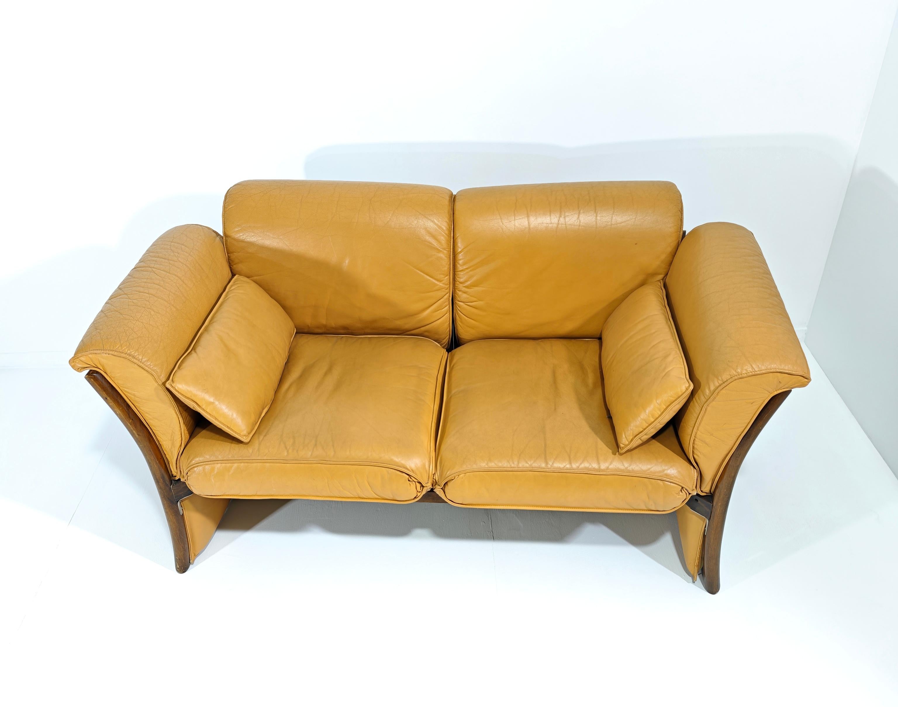 Beautiful leather sofa. Wooden frame with curved sides and decorated with a lattice pattern. The back, side and seat cushions are padded and covered in cognac leather with a zipper. Note the padding also on the lower part of the side. Made in Italy