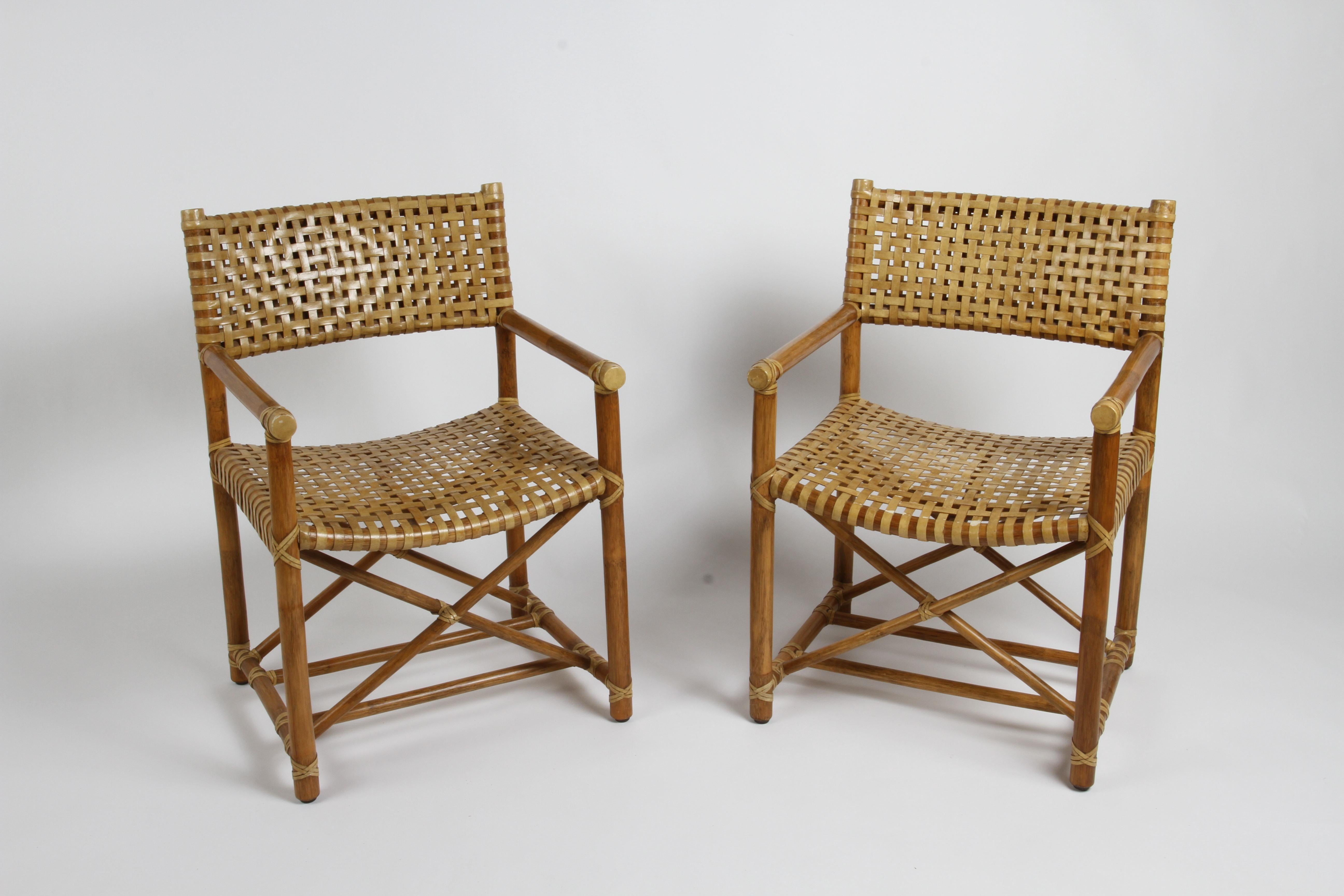Pair of Classic 1980s directors style McGuire dining or occasional armchairs with lattice style rawhide seats and backs. These rattan framed chairs with backrest and seat woven in rawhide. X-shaped supports held between legs with lower stretcher.