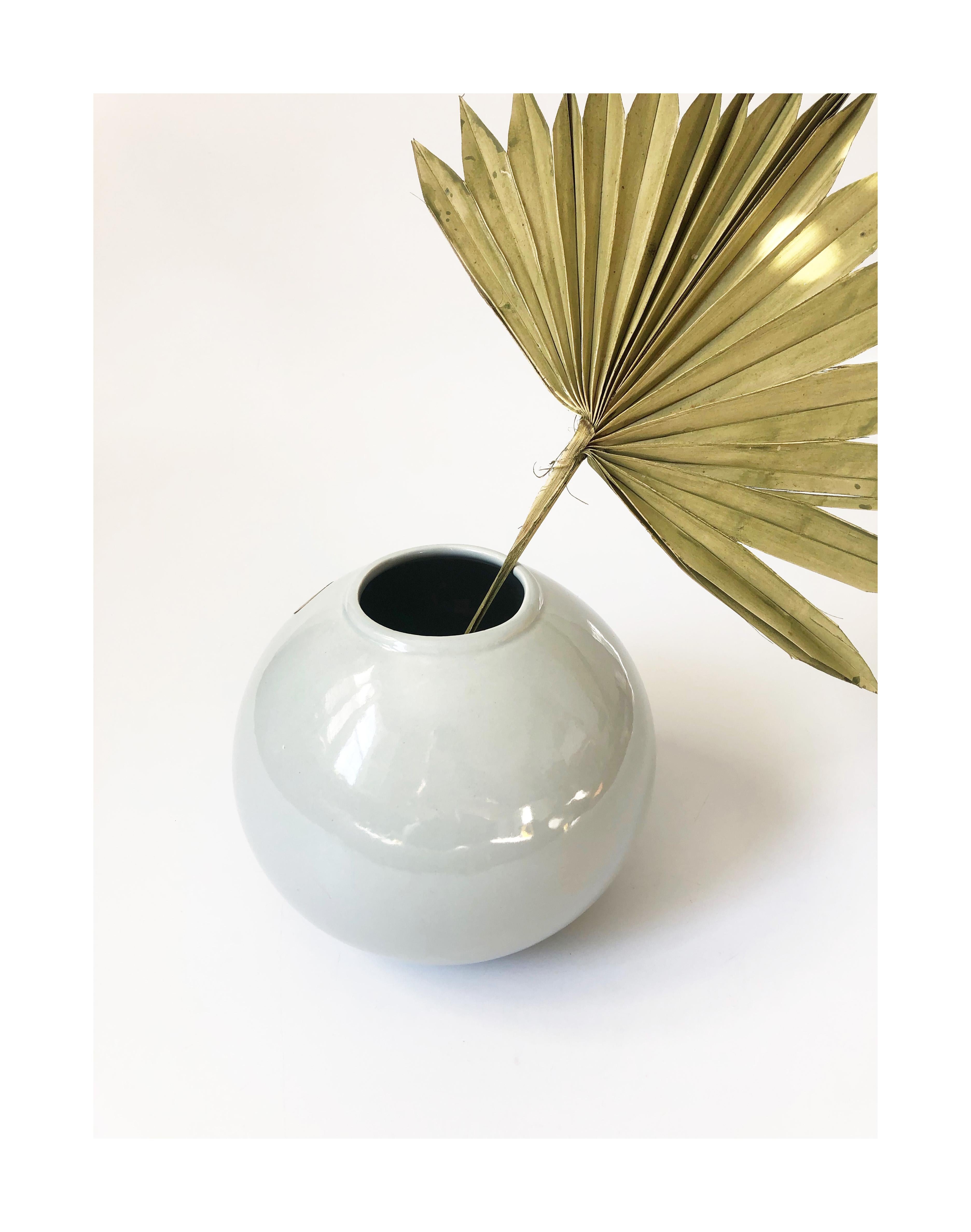 A vintage 80s ceramic sphere vase. High gloss pale gray finish in a simple modern shape. The orginal sticker by Seville Industries is still attached.
