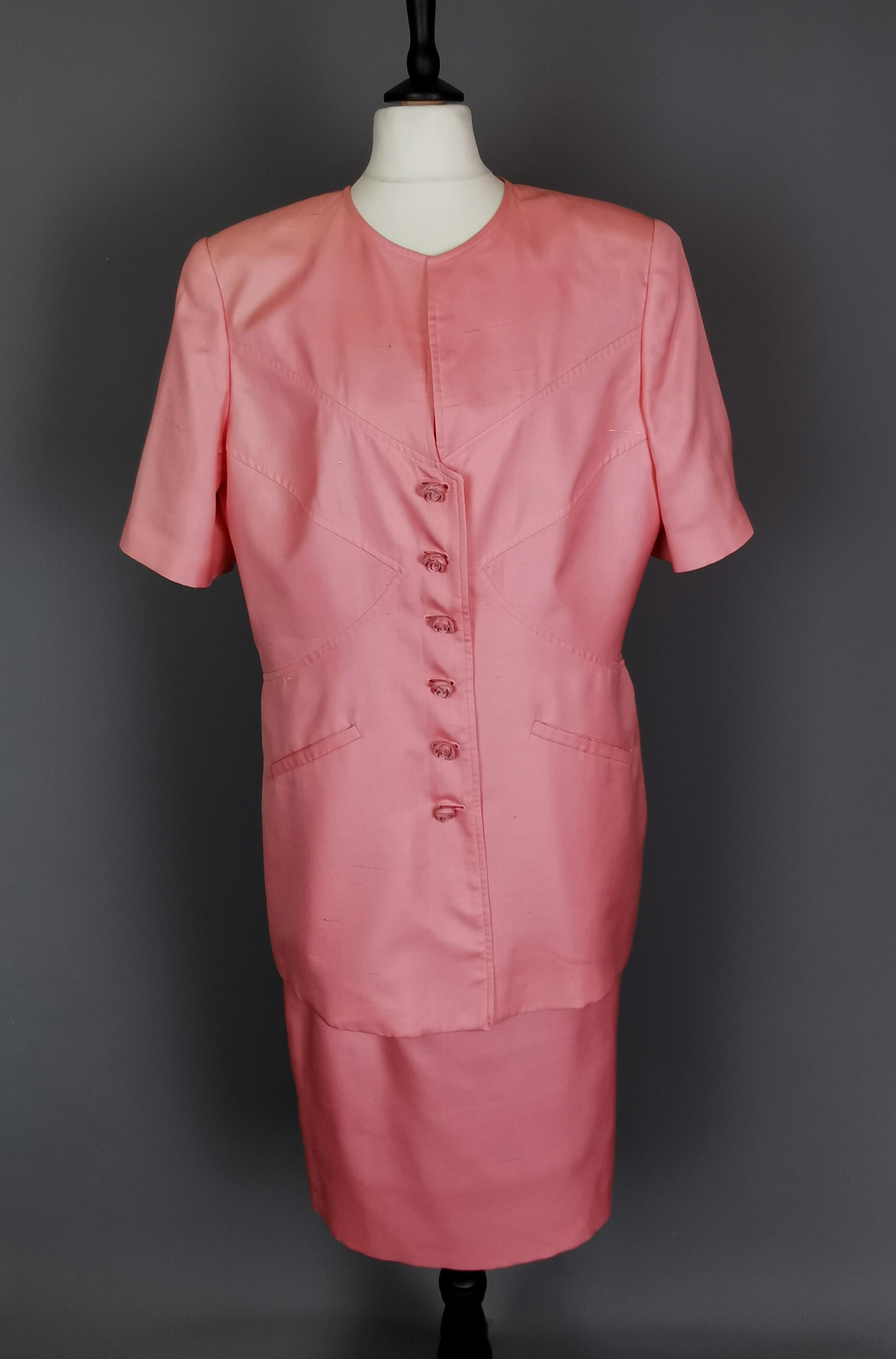 A gorgeous vintage 1980s skirt suit by Valentino.

This is the ultimate in feminine power dressing with the large boxy, padded shoulders contrasting with the pretty Rose stylised buttons.

Made from 100% silk it is a warm dusky pink shade.

The
