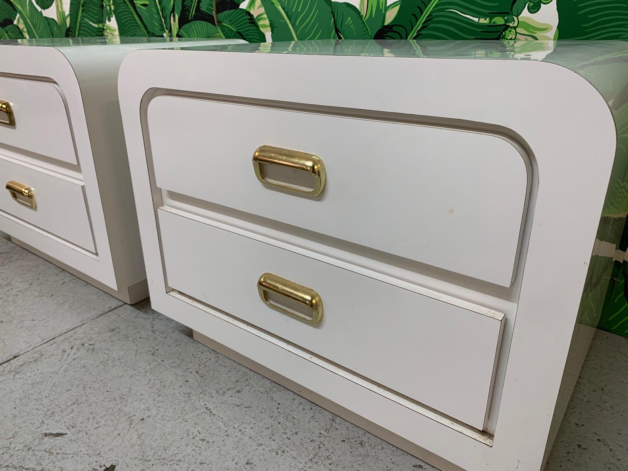 Vintage 1980s waterfall style night stands feature brass hardware and plinth base. Very good condition with only very minor imperfections consistent with age.