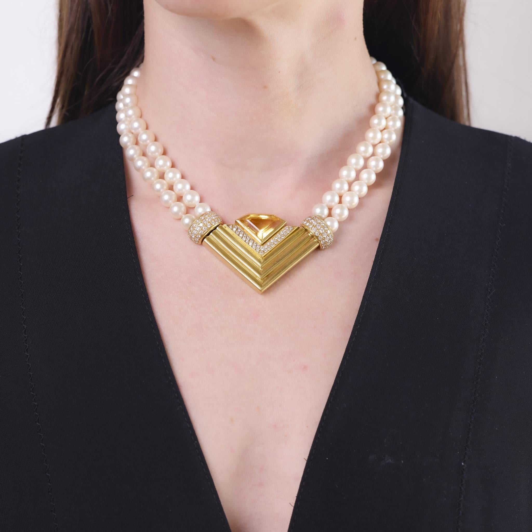This vintage French necklace from the 1980s features a striking shield cut citrine weighing approximately 8.40 carats. The centerpiece is framed by 102 round brilliant cut diamonds totaling approximately 2.04 carats, graded E-F color and VS clarity,