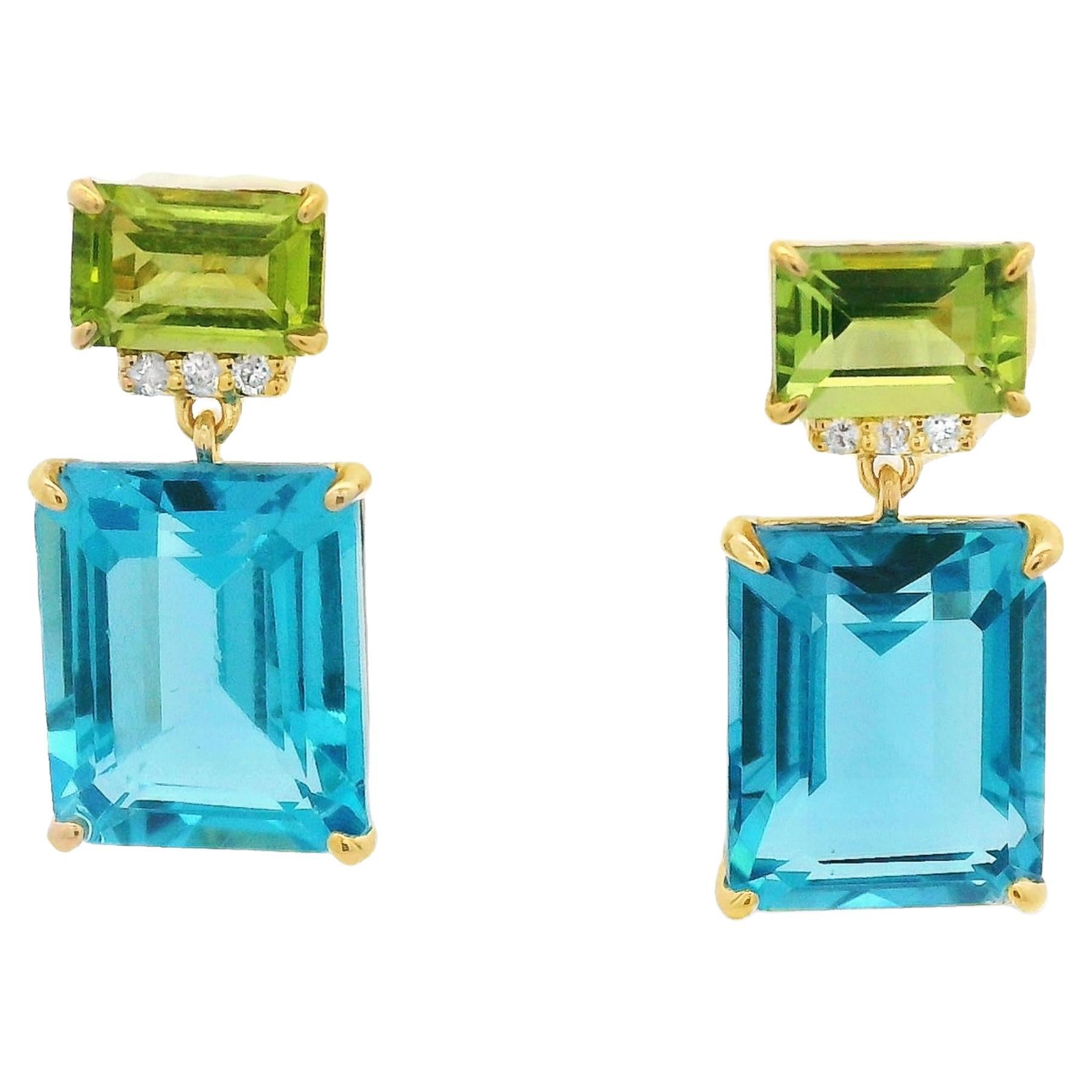 These stunning 14 Karat Gold earrings are a captivating expression of modern elegance and vibrant color. Featuring a bold combination of gemstones, each earring showcases a striking 8.43-carat blue topaz as the centerpiece, radiating clarity and
