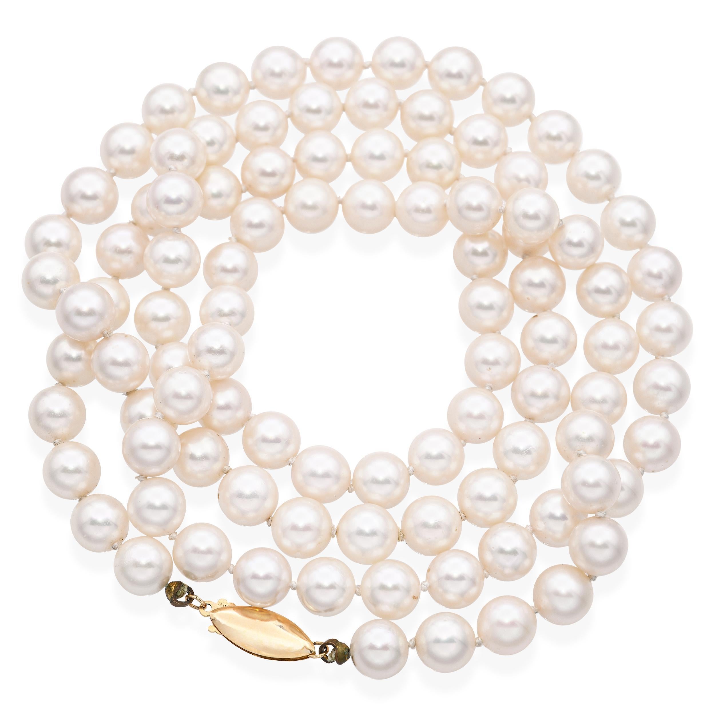 This classic vintage pearl necklace features a timeless strand of luminous, well-matched pearls secured with a refined 14k yellow gold clasp. The pearls display soft luster and subtle iridescence, offering a graceful glow that complements any style.