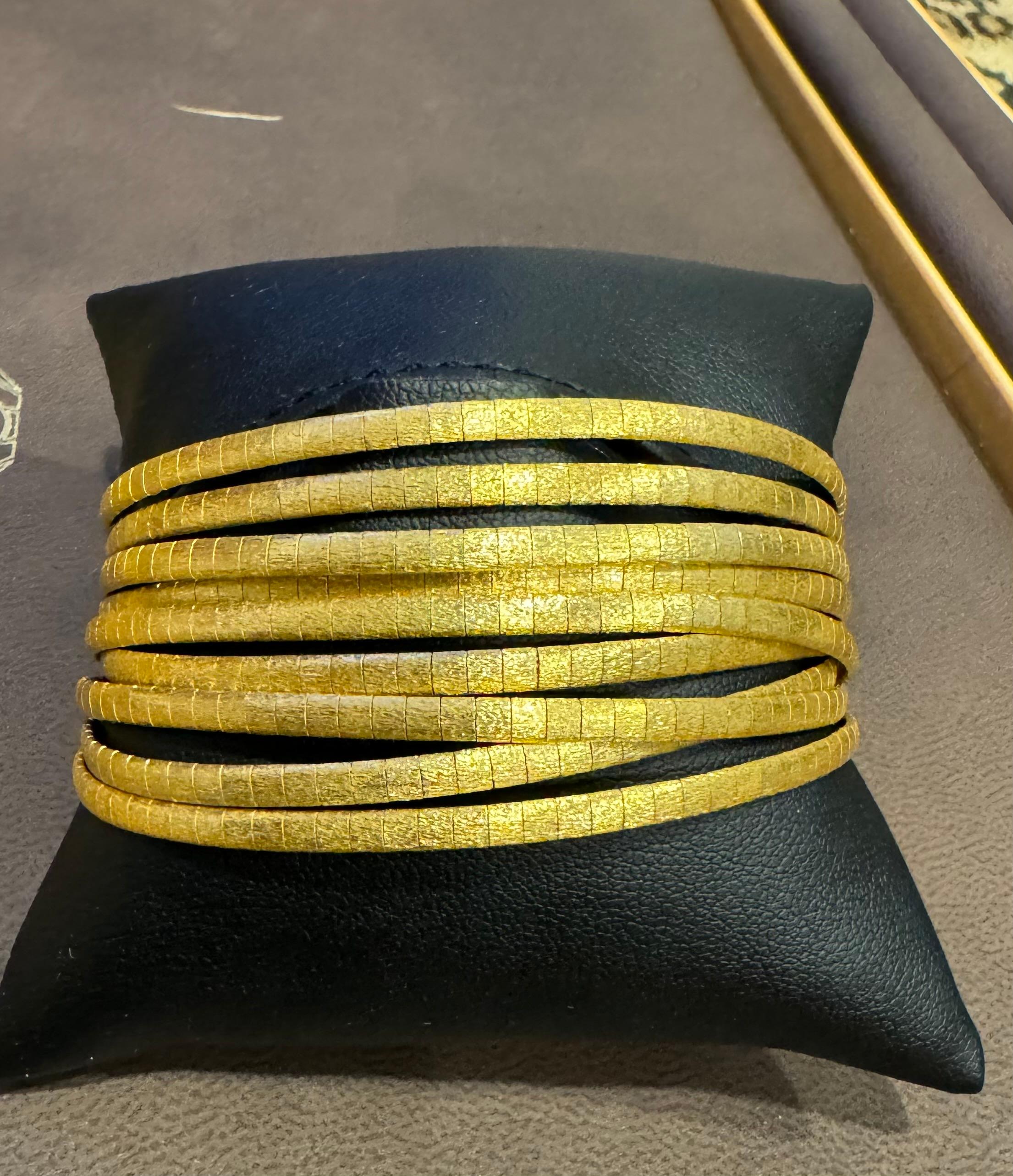 

This exquisite Vintage Hammered Gold bangle features a stunning design with nine attached bangles, all crafted in 18 Karat Yellow gold. With a substantial weight of 76 grams, this bangle showcases the quality of the 18 Karat gold used. It is