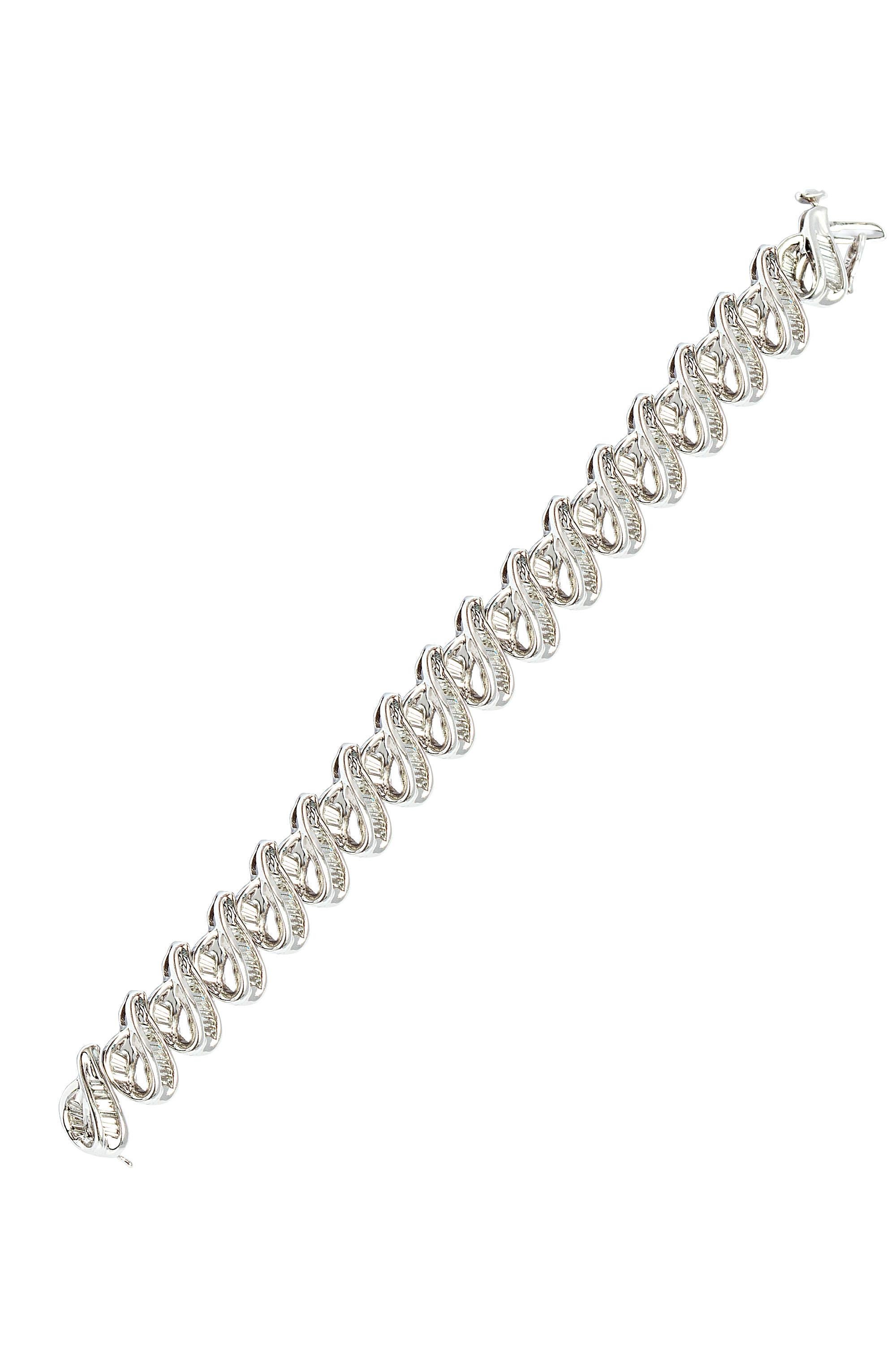 Gleaming paisley shaped links of polished 14 karat white gold and channel set baguette diamonds compose this sophisticated and sleek vintage bracelet. The bracelet contains baguette cut diamonds G VS quality, weighing approximately 9.00 carats in