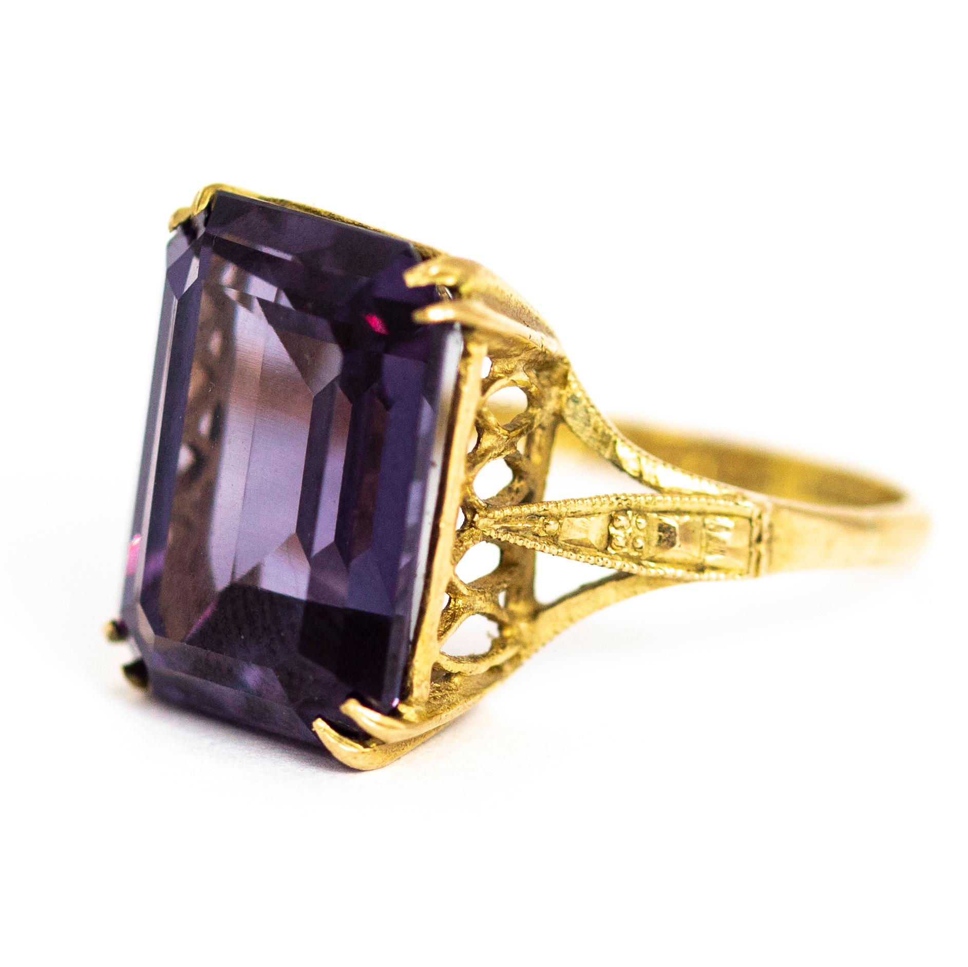 A stunning vintage 1960s cocktail ring set with a wonderful deep purple emerald cut amethyst. The stone is set in a beautiful open lattice gallery. Modelled in 9 carat yellow gold. Fully hallmarked 1961 Birmigham, England.

Ring Size: UK O, US 7