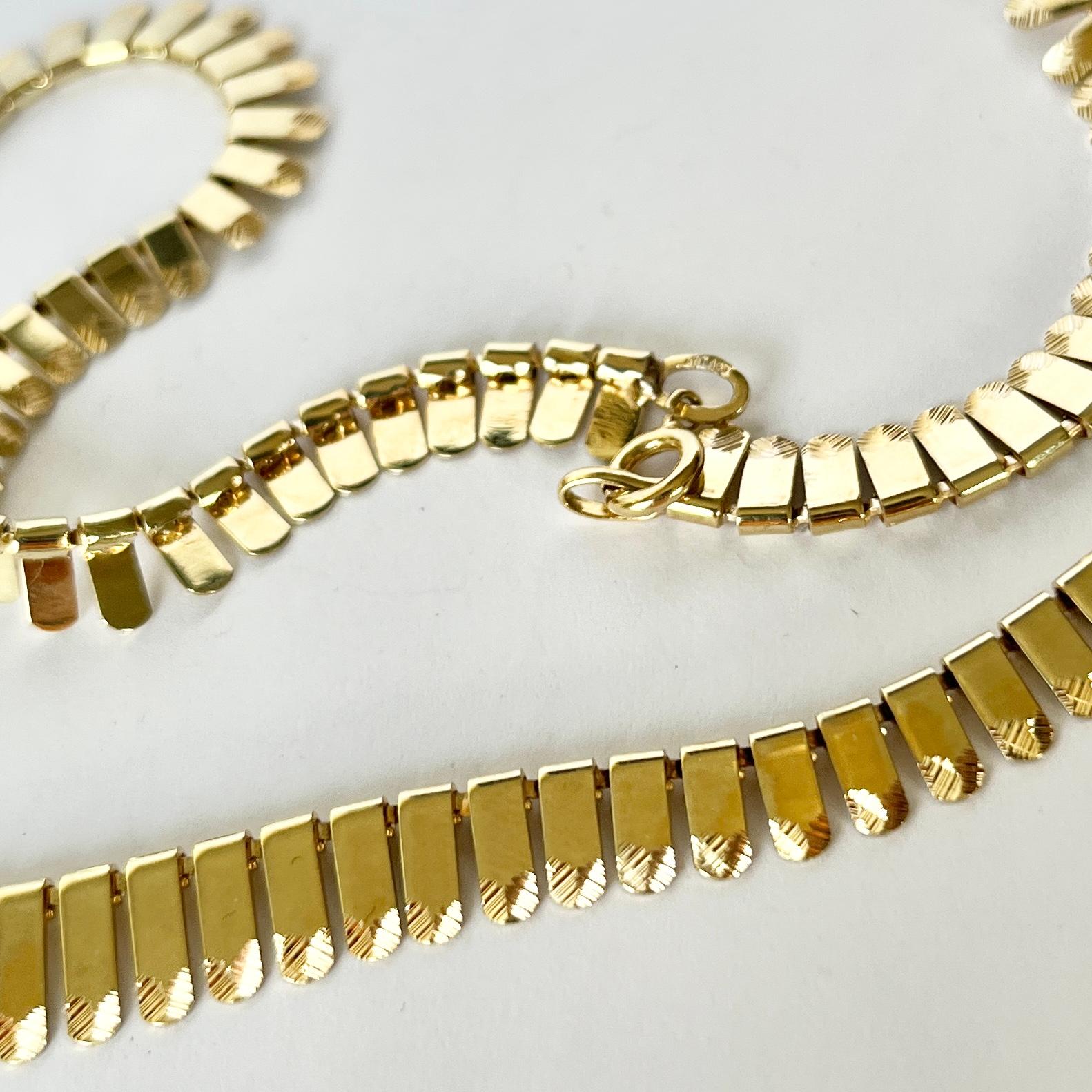 This beautiful vintage 9ct gold collar is flat and sits beautifully. It is fastened using a simple clasp. Fully hallmarked Birmingham 1977.

Length: 42cm
Widest and Slimmest Point: 10-6.5mm 

Weight: 16g