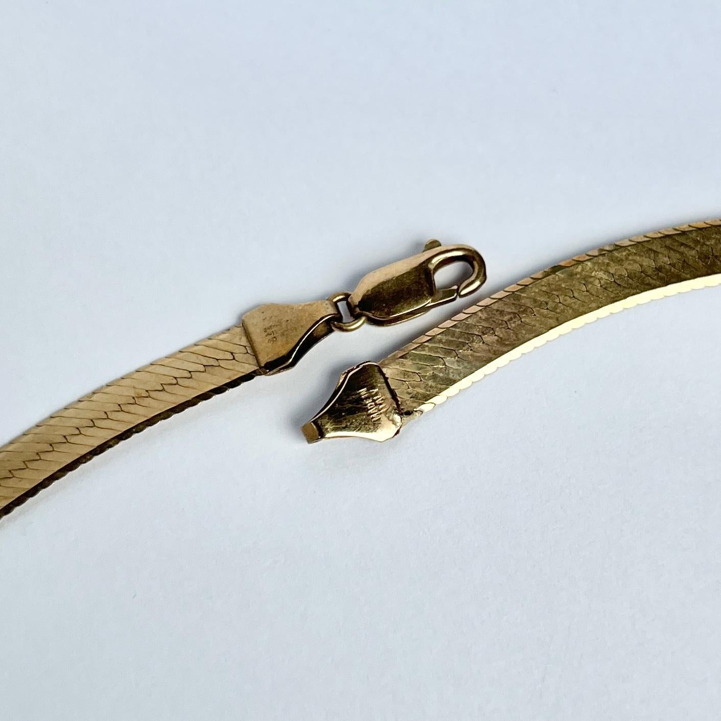 This beautiful vintage 9ct gold collar is flat and sits beautifully. It is fastened using a simple clasp.

Length: 40.5cm
Width: 6mm 

Weight: 8.6g