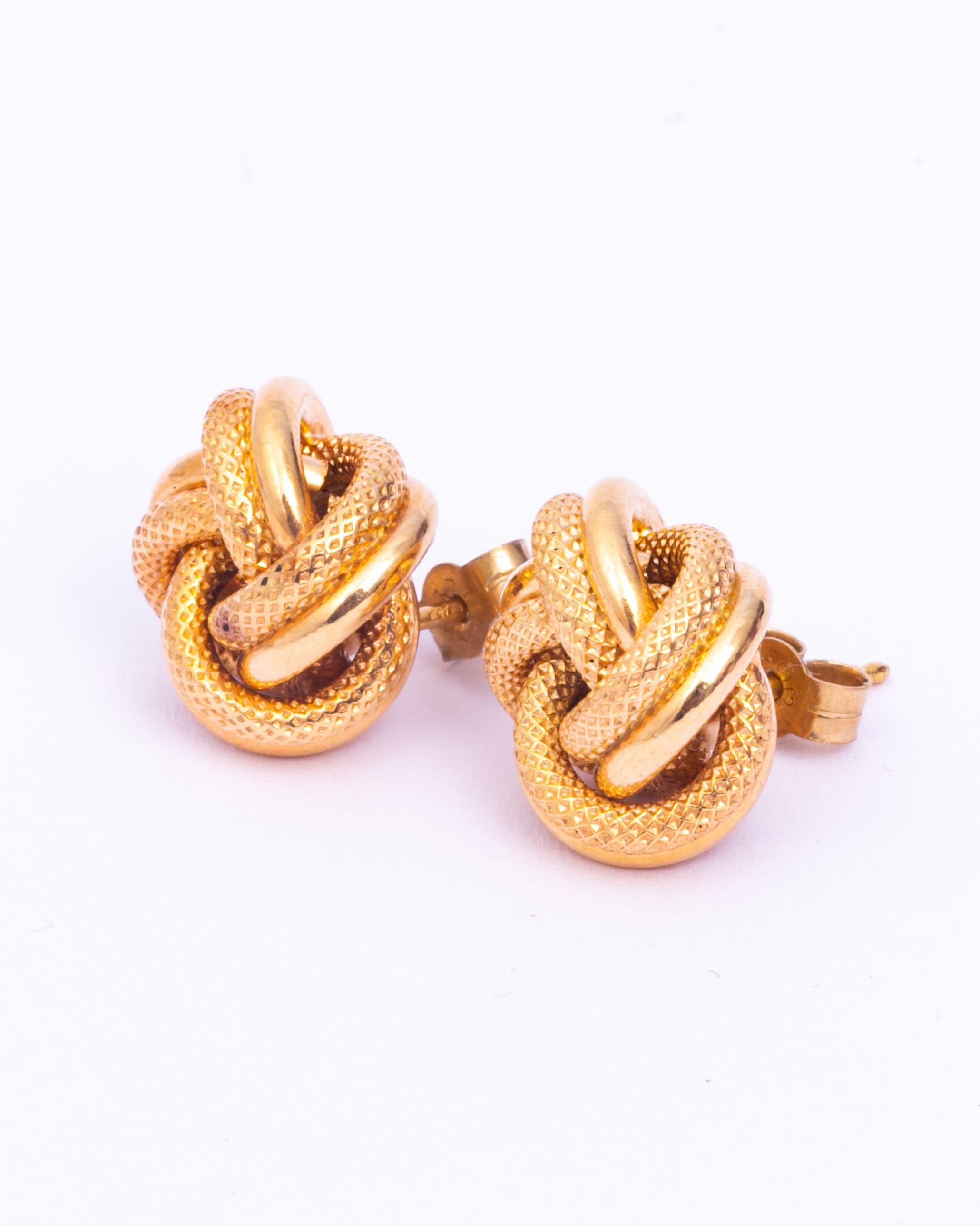 These earrings are super stylish and are modelled in glossy 9ct gold. The knots have a couple of strands which are smooth and a couple of strands that are finely engraved with gorgeous texture.

Diameter: 17mm 

Weight: 4.5g