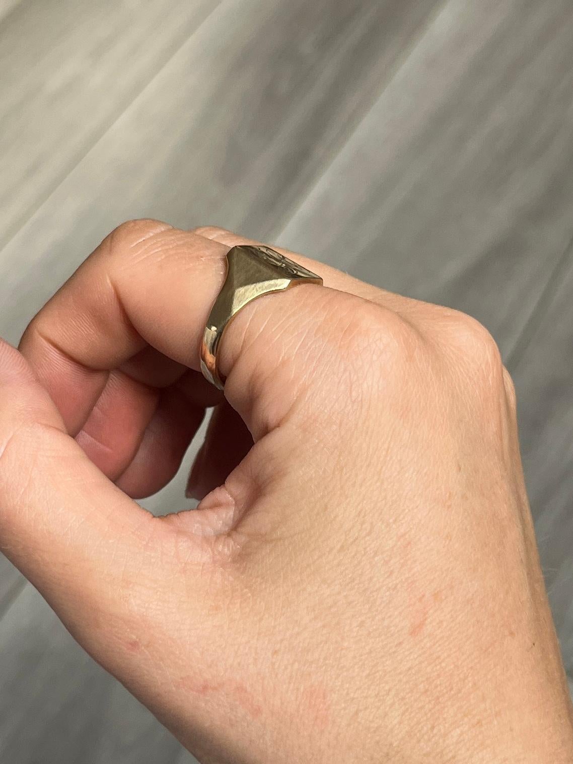 This signet is modelled in 9ct gold. The colour of the ring is bright yellow gold. Initials 'GA' engraved onto the face. Fully hallmarked Birmingham 1917.

Ring Size: U 1/2 or 10 1/4 
Face Diameter: 12x10mm 

Weight: 4.9g
