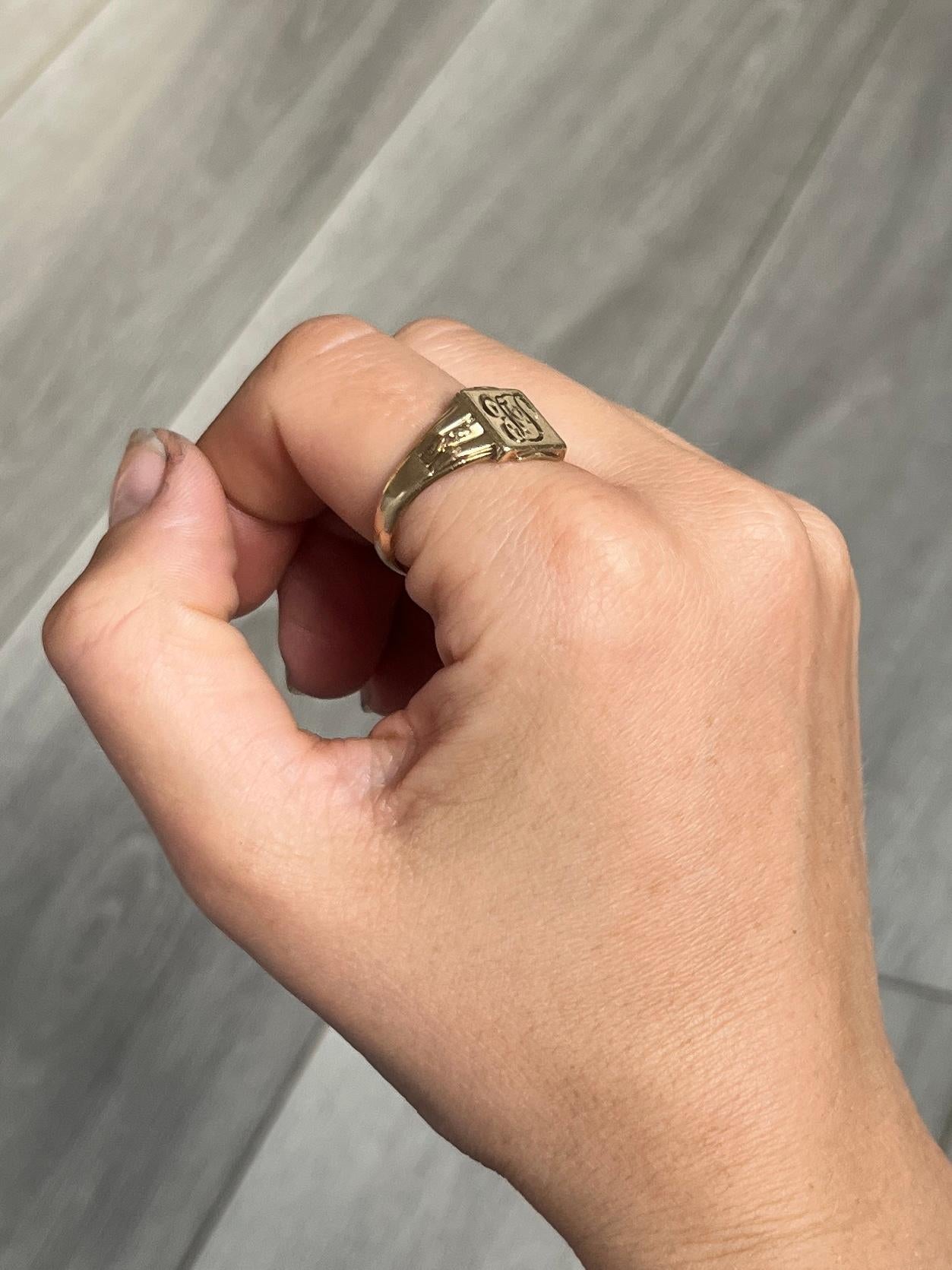 This signet is modelled in 9ct gold. The colour of the ring is bright yellow gold. Initials 'FP' engraved onto the face. Fully hallmarked Birmingham 1976. The back of the face has some engraving which reads 'Best Wishes From Workmates'.

Ring Size: