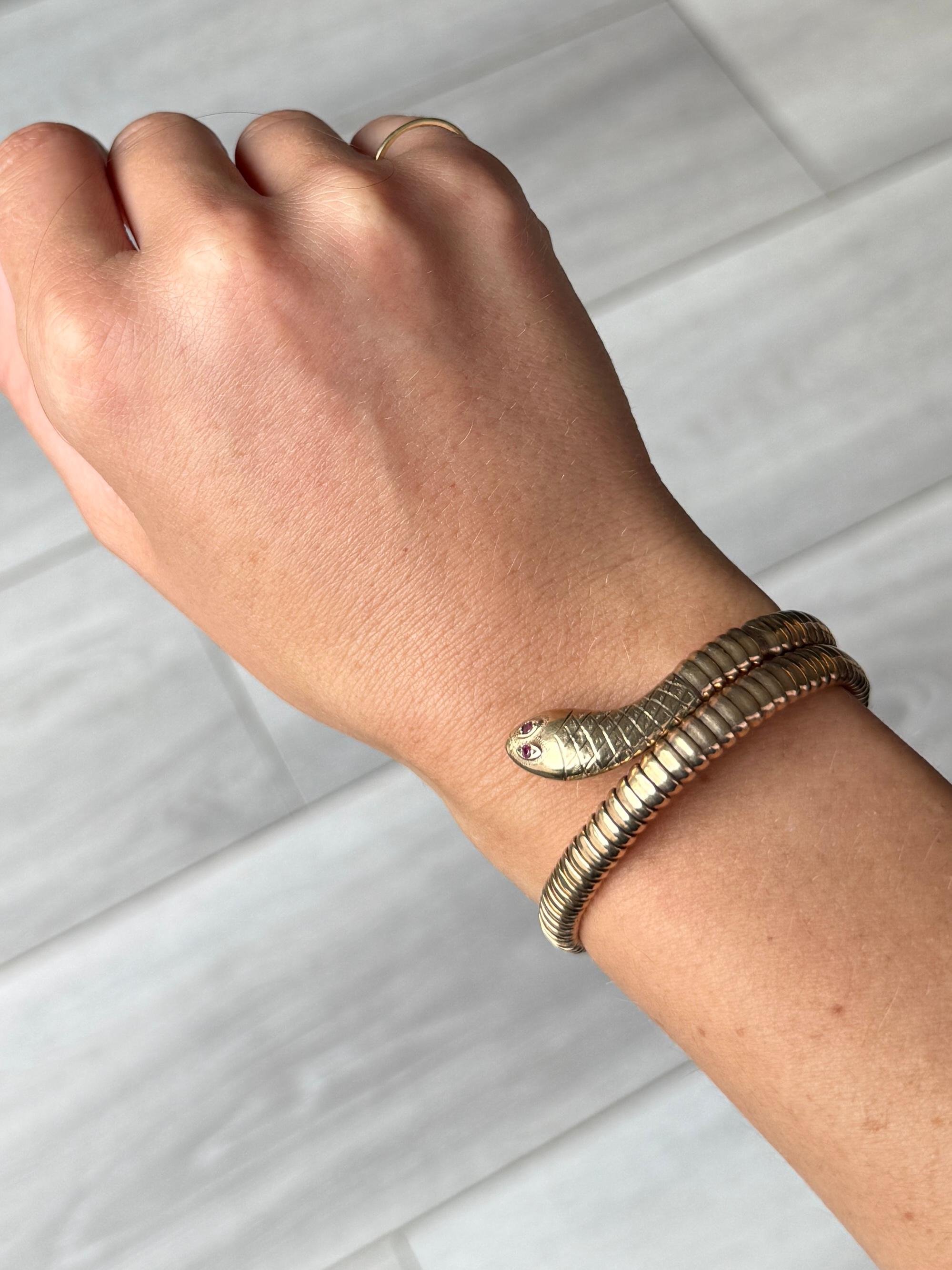 This snake is modelled in 9carat gold and expands to fit most wrist sizes. The snake head is set with two ruby eyes. Fully hallmarked Birmingham 1966.

Inner Diameter: Expandable
Bangle Width (in total): 20mm

Weight: 19.5g