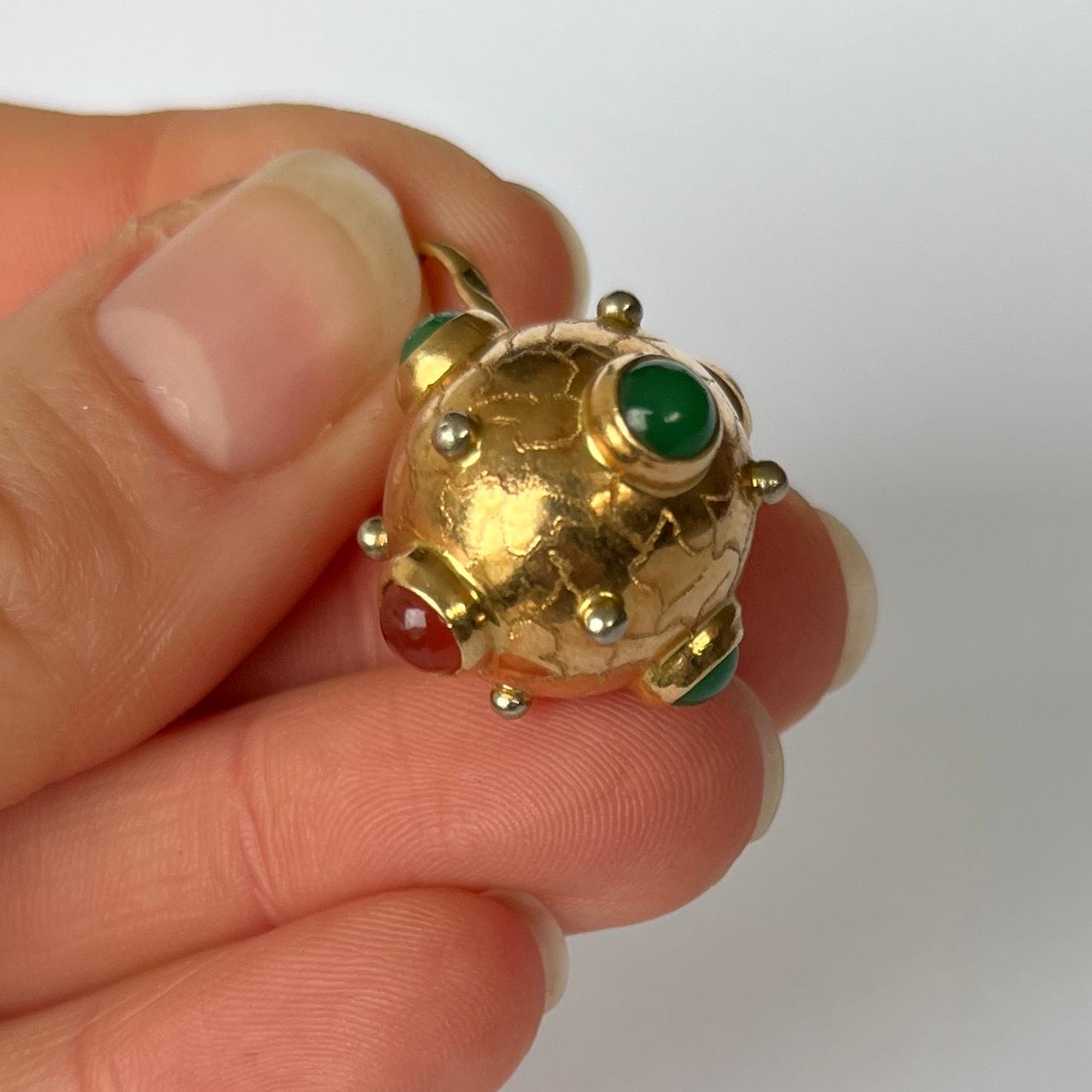 This pendant is modelled in 9 carat gold and is set with carnelian and jadeite. Each stone measures 4.5mm in diameter. 

Pendant drop from loop: 30mm

Weight: 5.4g