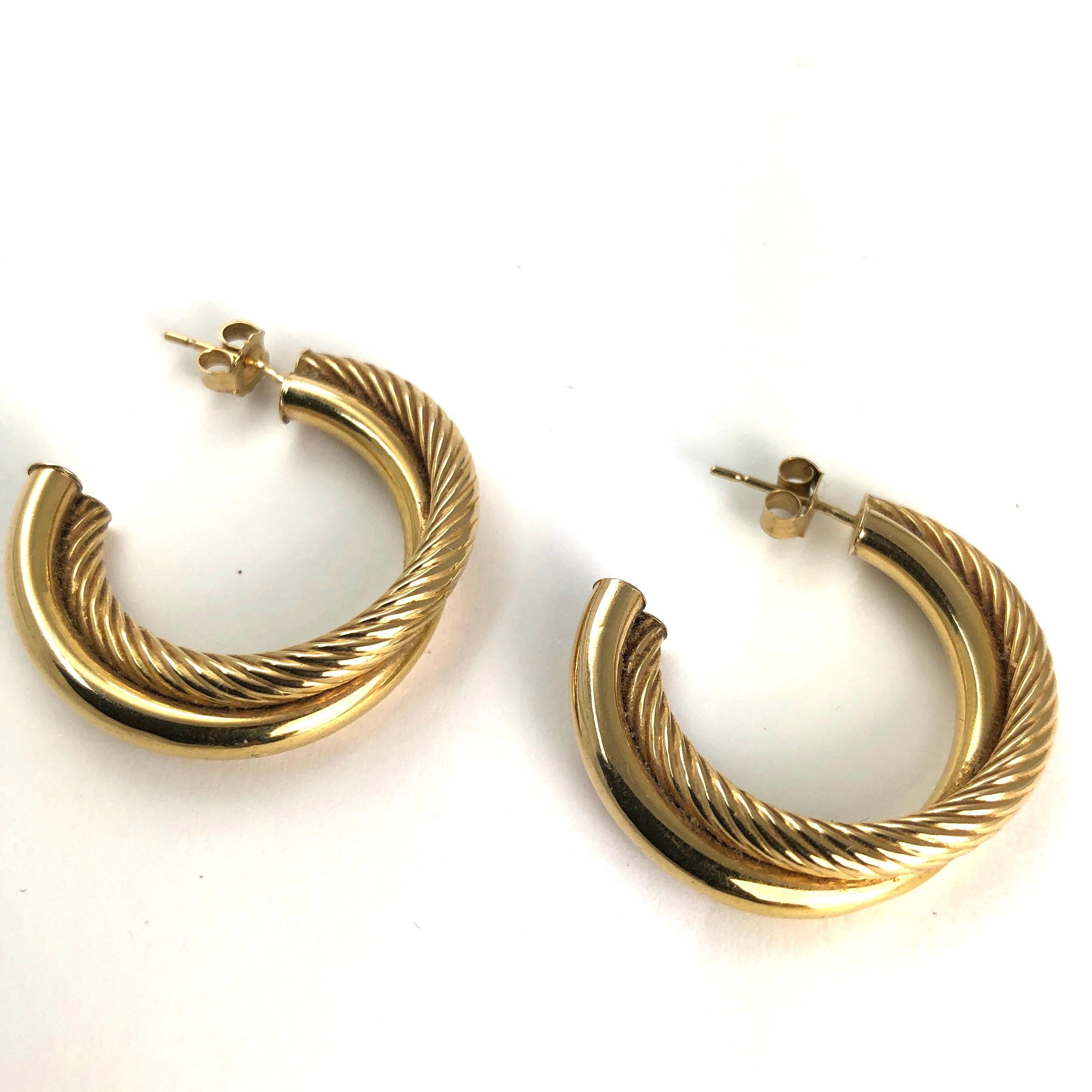 There are two textured hoops that intertwine to make up these gorgeous hoop earrings. One of the hoops is gorgeously smooth and glossy and the other is grooved from end to end.

Hoop Diameter: 1 1/8 inches

Weight: 2.8g