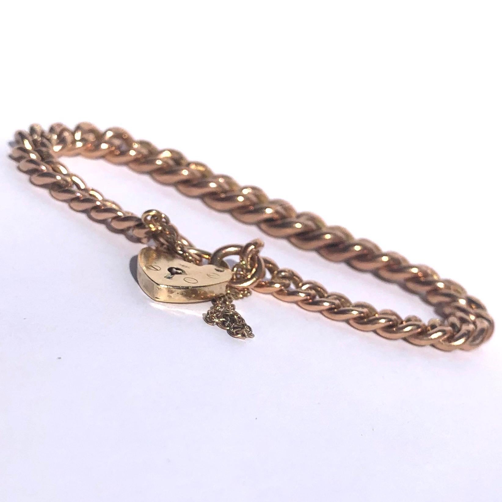 This is a classic curb bracelet modelled in 9ct rose gold and has a yellow gold heart padlock as the method of fastening. Every link in this bracelet is marked as 9ct gold. 

Length: 17.5cm 
Chain Width: 6mm

Weight: 26.5g