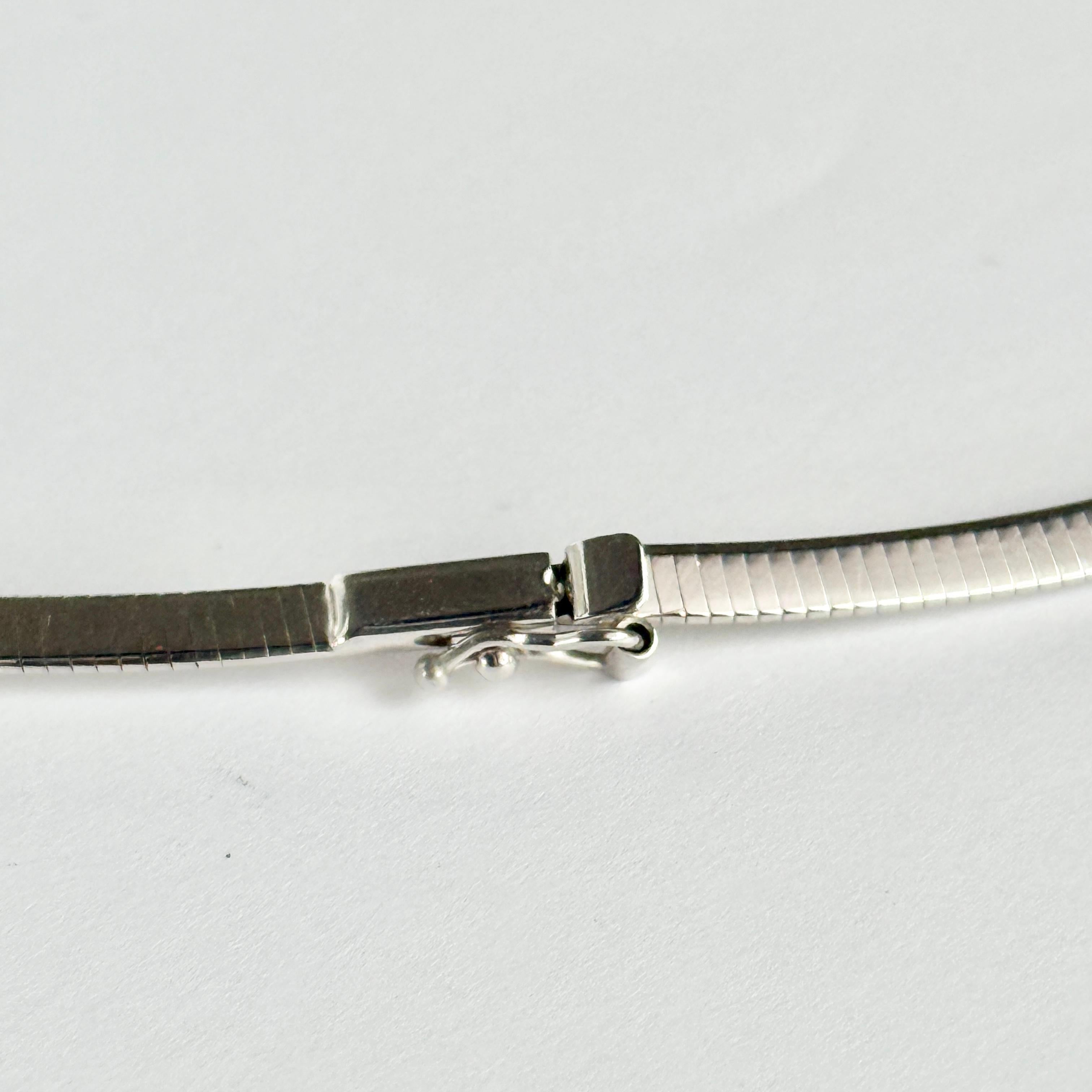 Questo bellissimo collare d'epoca in oro bianco a 9 carati è piatto e ha un'ottima posizione. Si chiude con una semplice fibbia.

Lunghezza: 43 cm
Larghezza: 3 mm 

Peso: 9g