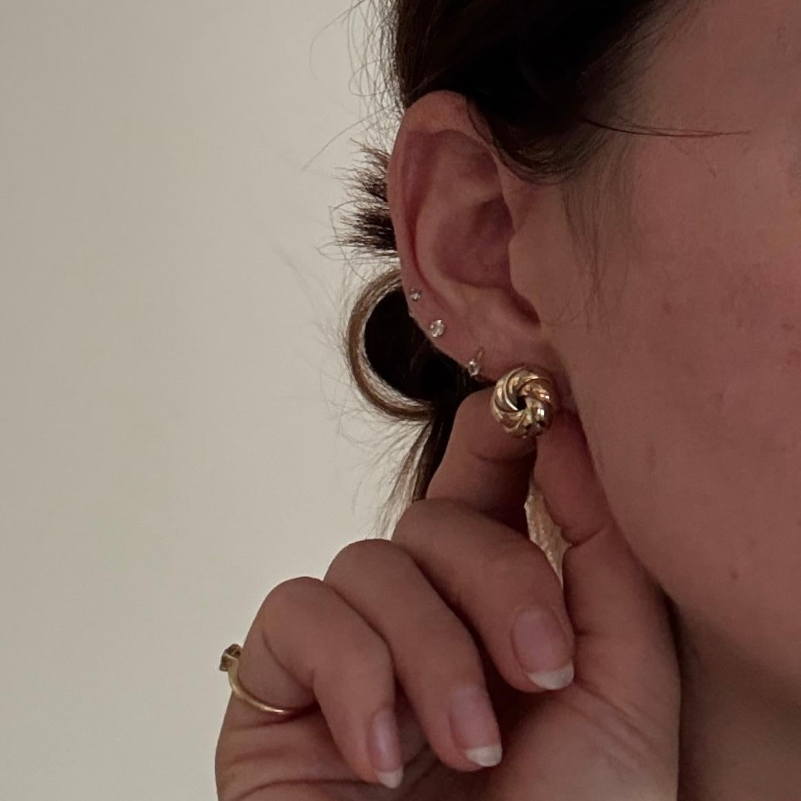 El brillante oro amarillo, rosa y blanco de 9 ct, magníficamente atado en un nudo, constituye el diseño más elegante para estos pendientes. 

Diámetro del nudo: 13 mm
Altura desde la oreja: 7,5 mm

Peso: 2.1 g