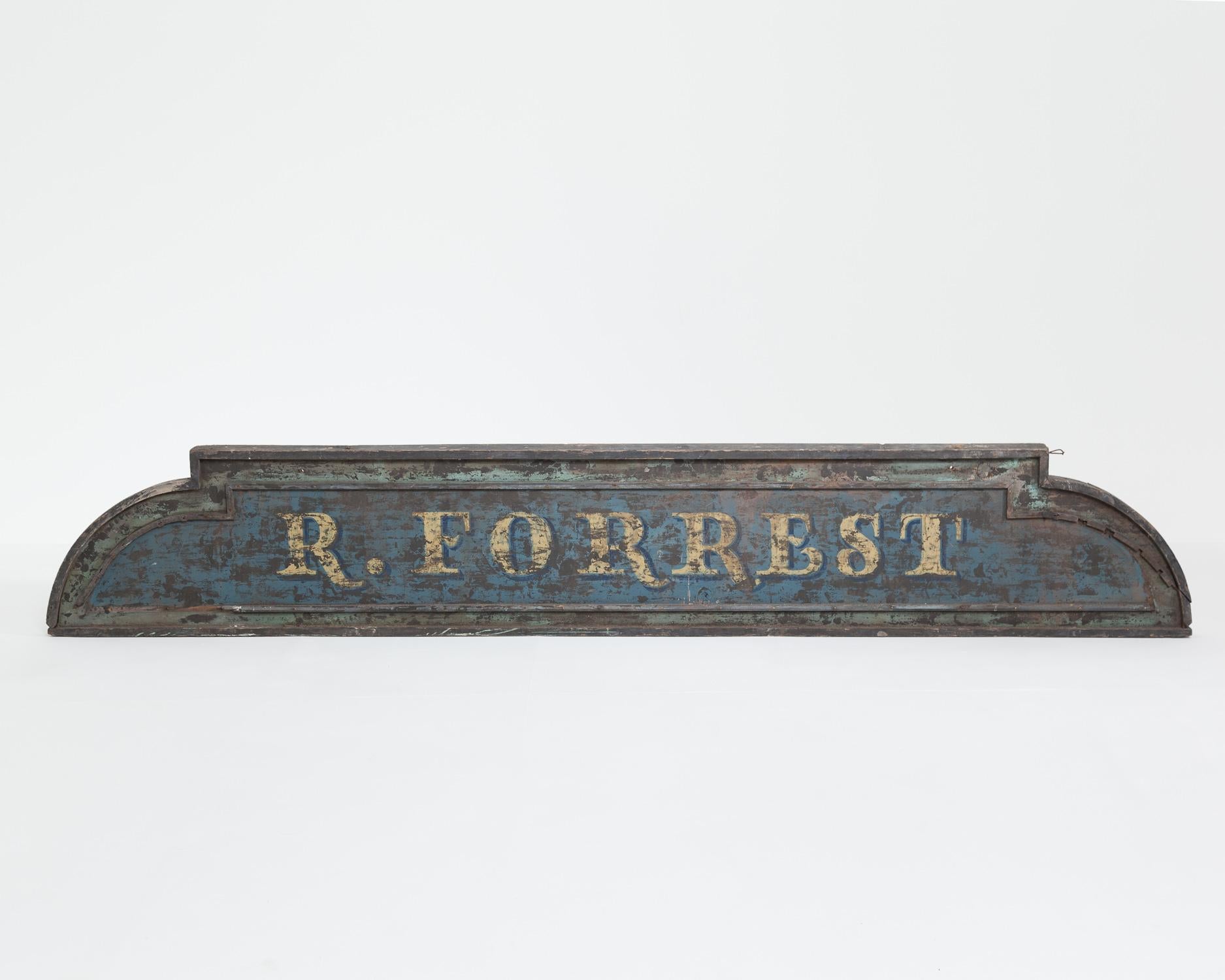 Very impressive wooden vintage English shop sign, which reads ‘R. Forrest’.

It was reputedly from the Gloucestershire area.

Measures: Height 48cm x width 291cm x depth 8cm.
 