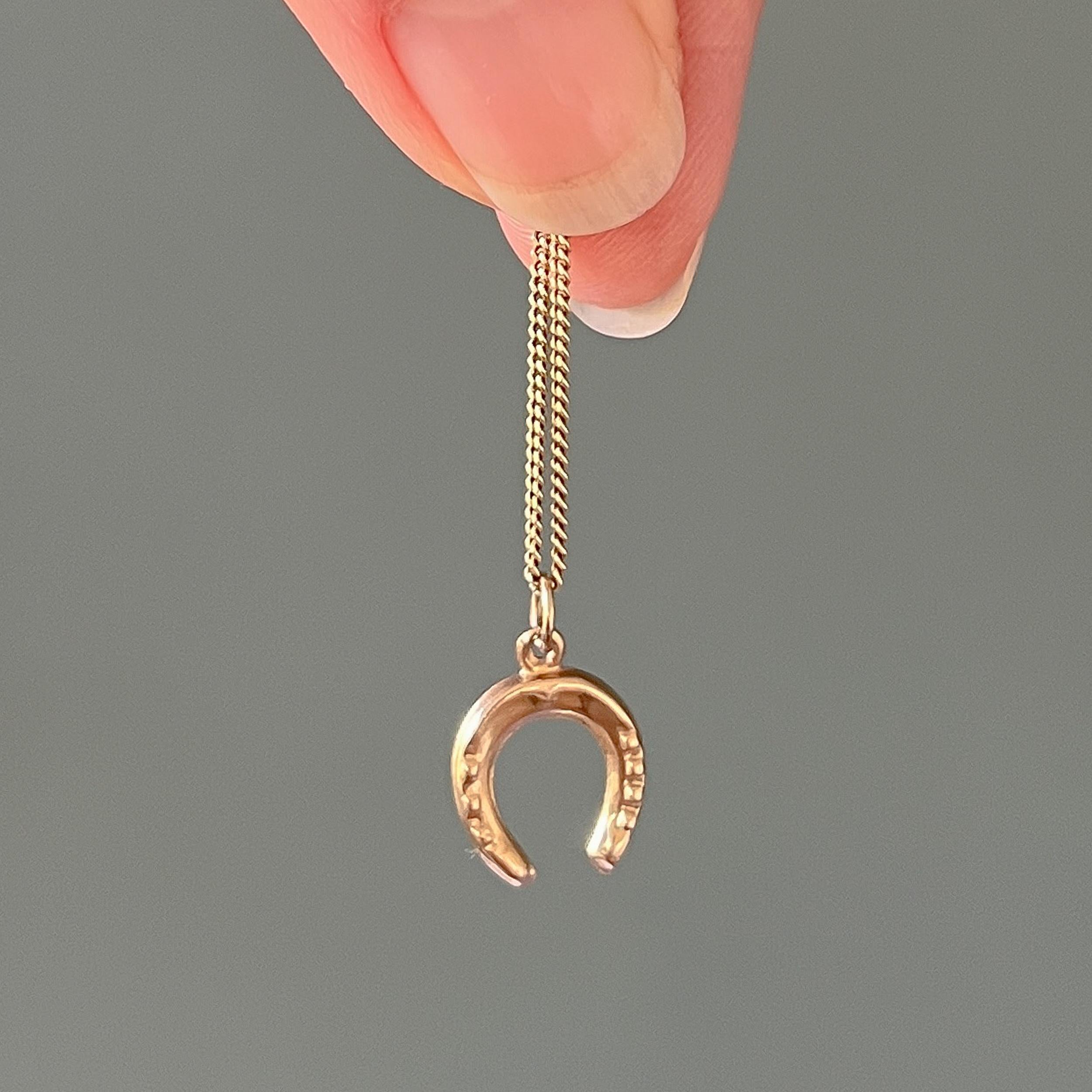 A vintage 9 karat yellow gold lucky horseshoe charm pendant. This miniature horseshoe charm is nicely detailed. The horseshoe is universally known as a symbol of protection and good luck. The amalgamation of luck, protection and religion have made