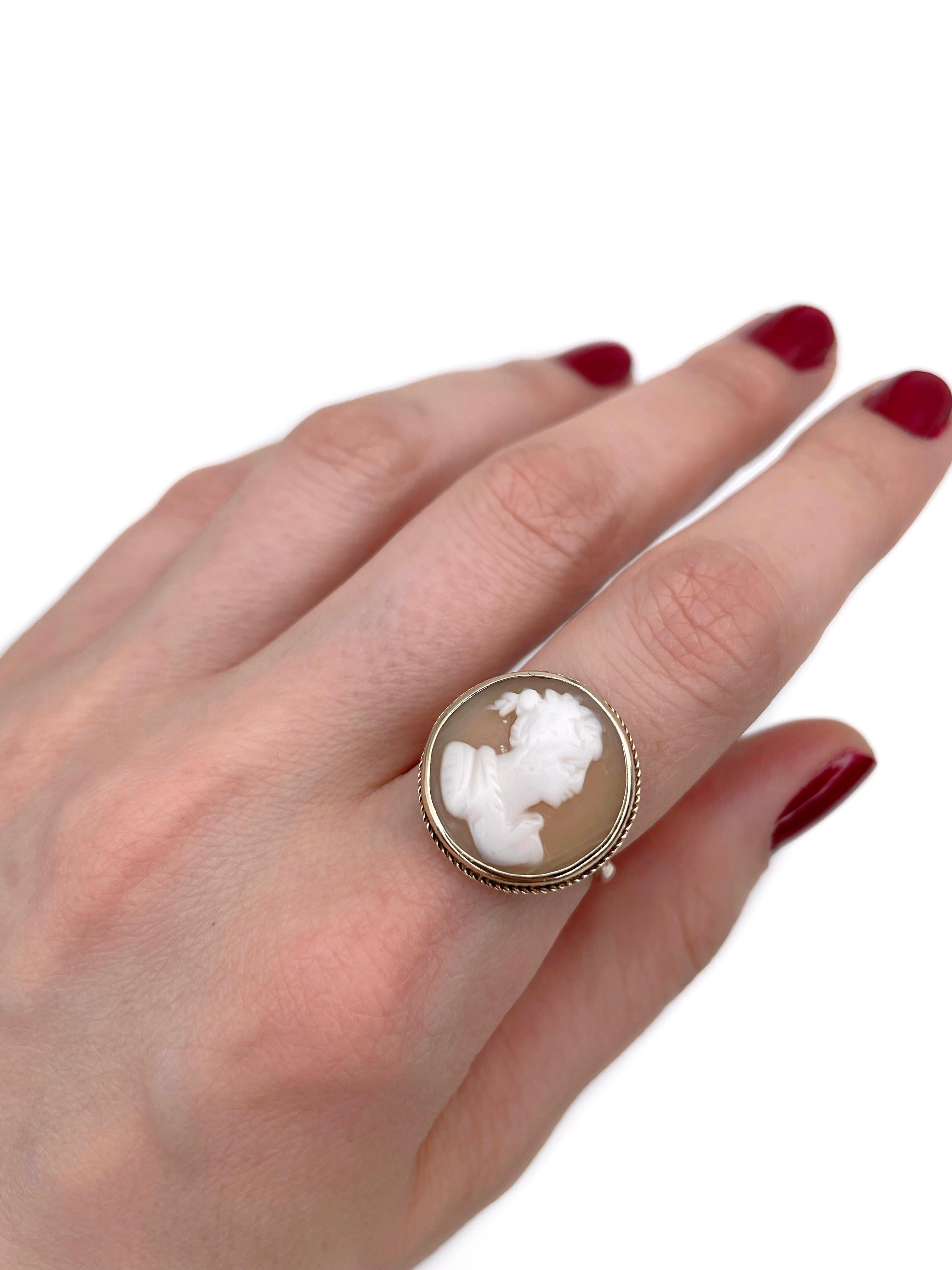 Si tratta di un anello con sigillo vintage realizzato in oro 9K. Circa 1960. 

Il pezzo presenta un cammeo di conchiglia che raffigura una donna rivolta verso destra. 

Firmato 