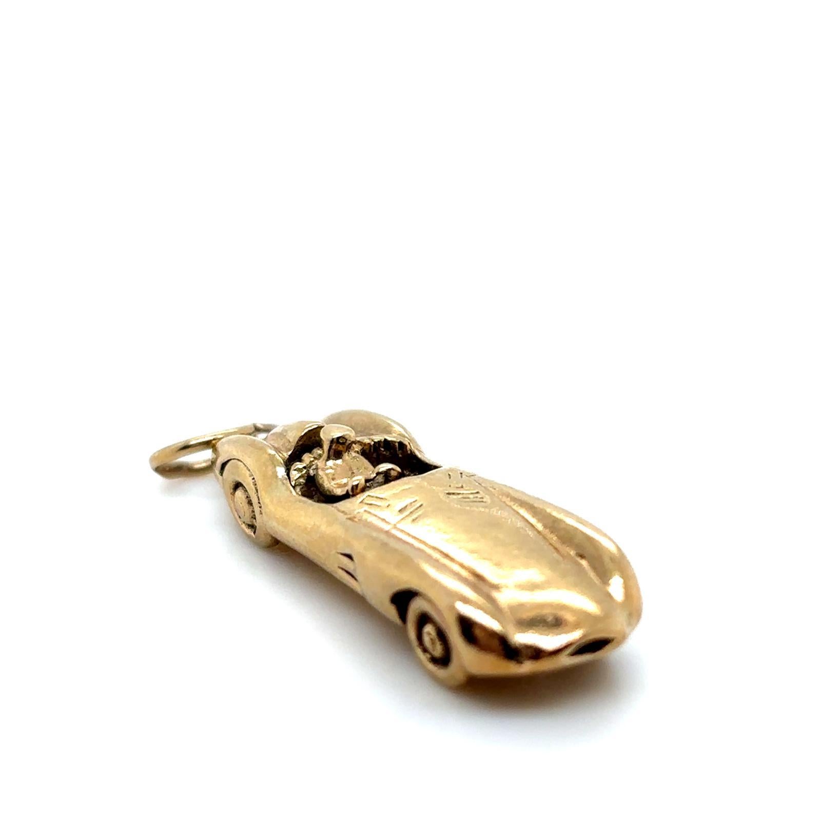 A vintage 9 karat yellow gold Aston Martin DBR1 racing car charm, circa 1980

Realistically modelled as a classic Aston Martin DBR1 racing car, featuring a driver seated on engraved leather detailed seats, and finished with an oval bale on which to
