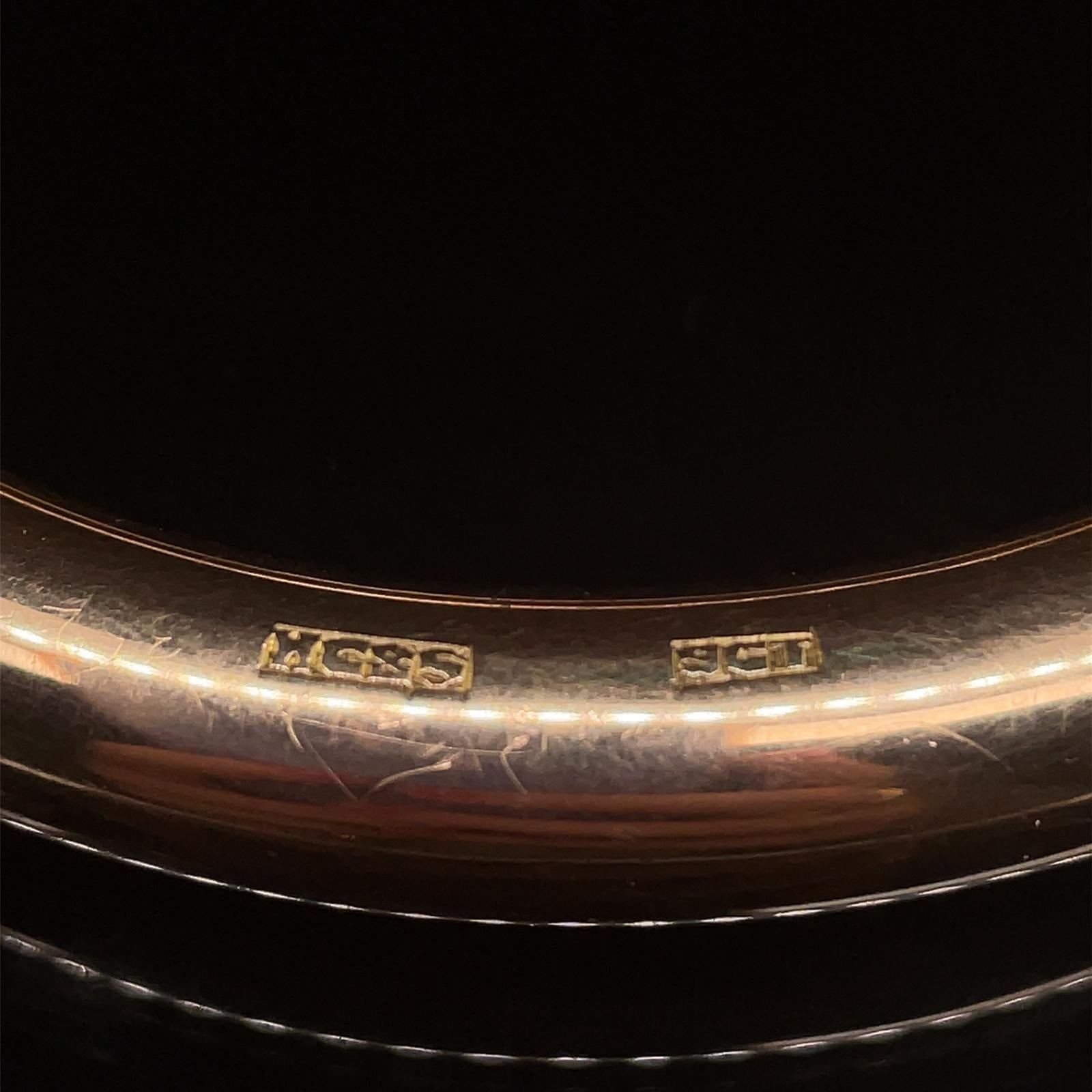 An elegant yellow gold bangle by Henry Griffith & Sons, circa 1940

Rounded and hollow, with a plain polished finish and crafted in 9 karat yellow gold.

This bangle's rounded finish allows it to be slipped on and off easily whilst also being