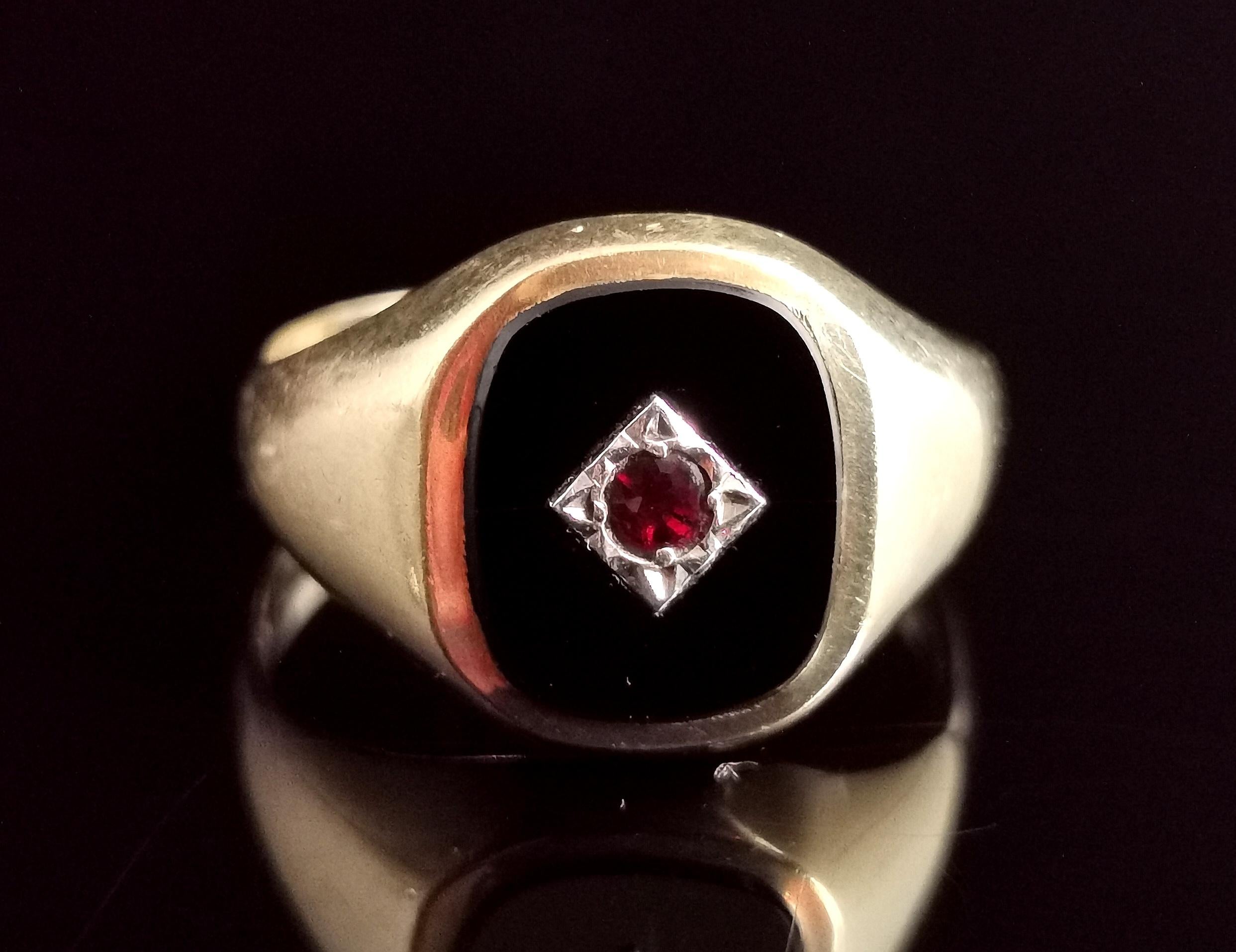 Vintage 9kt yellow gold Onyx and garnet signet ring.

An attractive and chunky gold signet ring with a central black polished onyx panel star set with a single garnet in silver.

It has a smooth yellow gold band with heavy tapering shoulders.

It is
