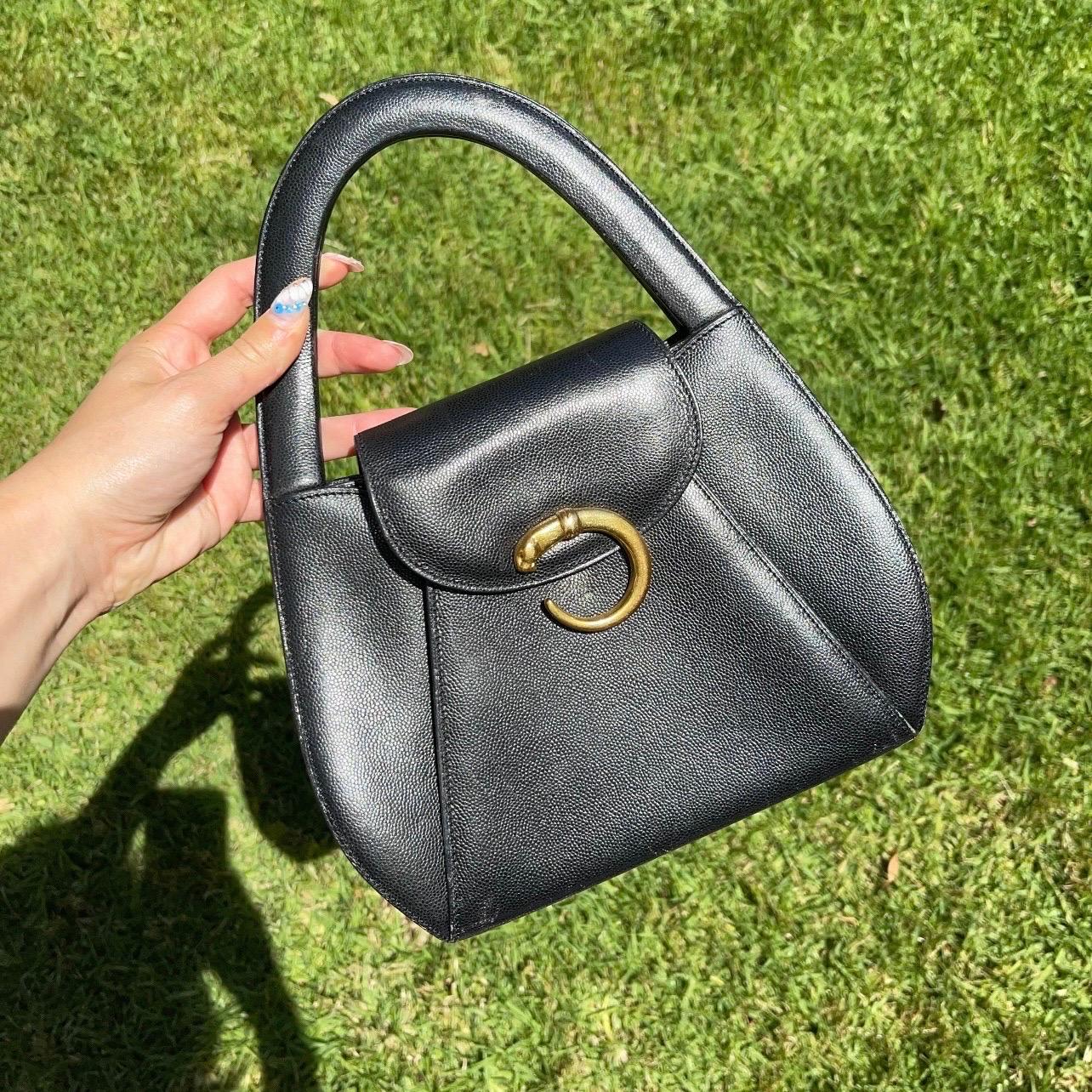 This stunning bag is such a rare treasure in immaculate condition!

Perfectly structured, with a chic silhouette and rounded handle. Featuring the signature Cartier panther in gold tone, two rounded top handles, fold over snap closure. Inside the