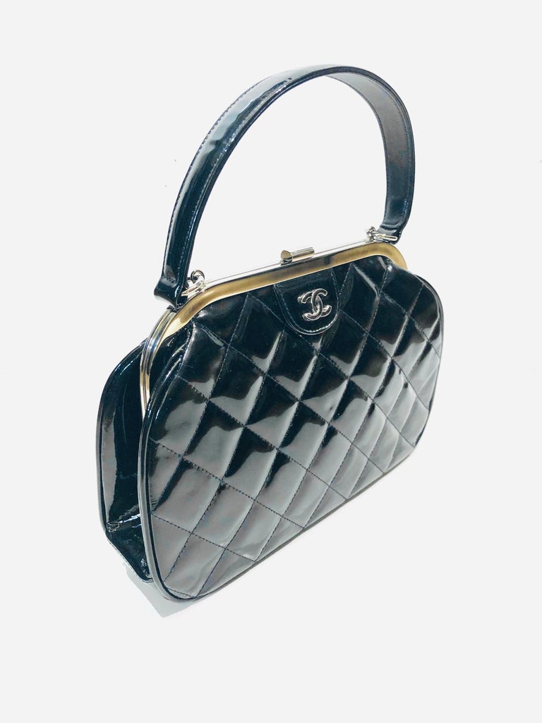 - Vintage 90s Chanel classic black quilted patent leather handbag. 

- Kiss lock closure. 

- Interior zip closure. 

- One interior slip pocket. 

- Silver Hardware. 

- Measurements: Length: 25cm. 
                             Height: 17cm. 
     