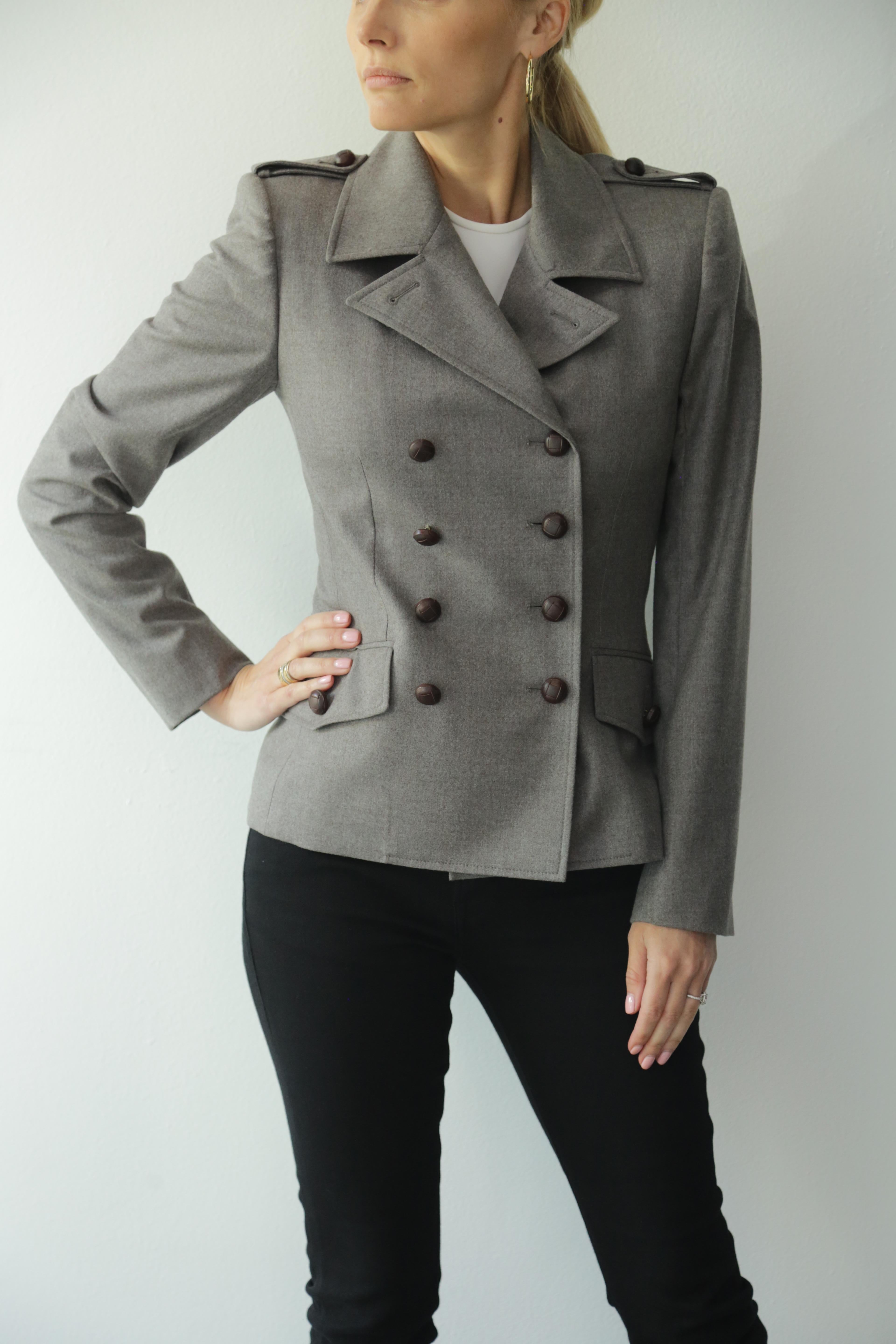 Yves Saint Laurent Vintage, graue Blazerjacke mit braunen Lederknöpfen. 90er Jahre Jahrzehnt. 
Die Jacke kann mit hochgeknöpftem Kragen oder mit offenem Kragen und umgeschlagen wie ein Blazer getragen werden.
Toller Zustand. 
97% Schurwolle, 3%