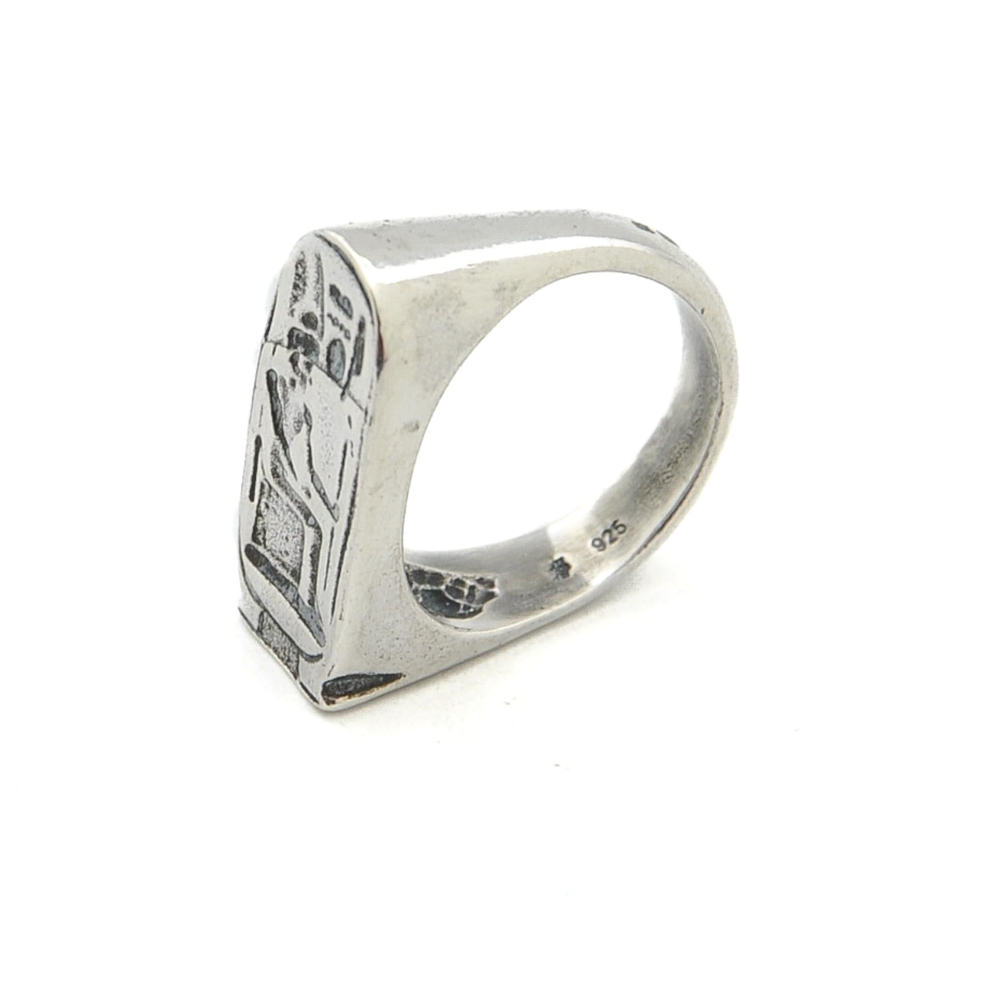 A beautiful Egyptian Revival stirrup-shaped ring depicting a pharaoh with Egyptian hieroglyphic symbols. The pharaoh sits on his throne and holds a scepter in his hand. Some Egyptian hieroglyphs can be seen above the pharaoh. These were symbols of