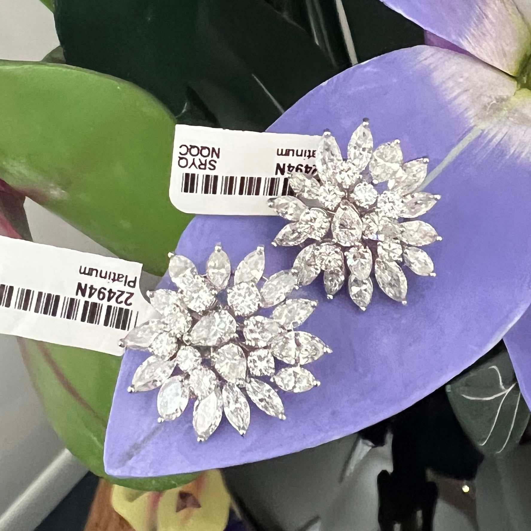Platinum 9.50 carat cluster diamond stud earrings feature an array of round, marquise, and pear-shaped diamonds. With 48 diamonds weighing an estimated 9.50 carats, these earrings sparkle with impressive brilliance. The diamonds are G-H color, VS-SI