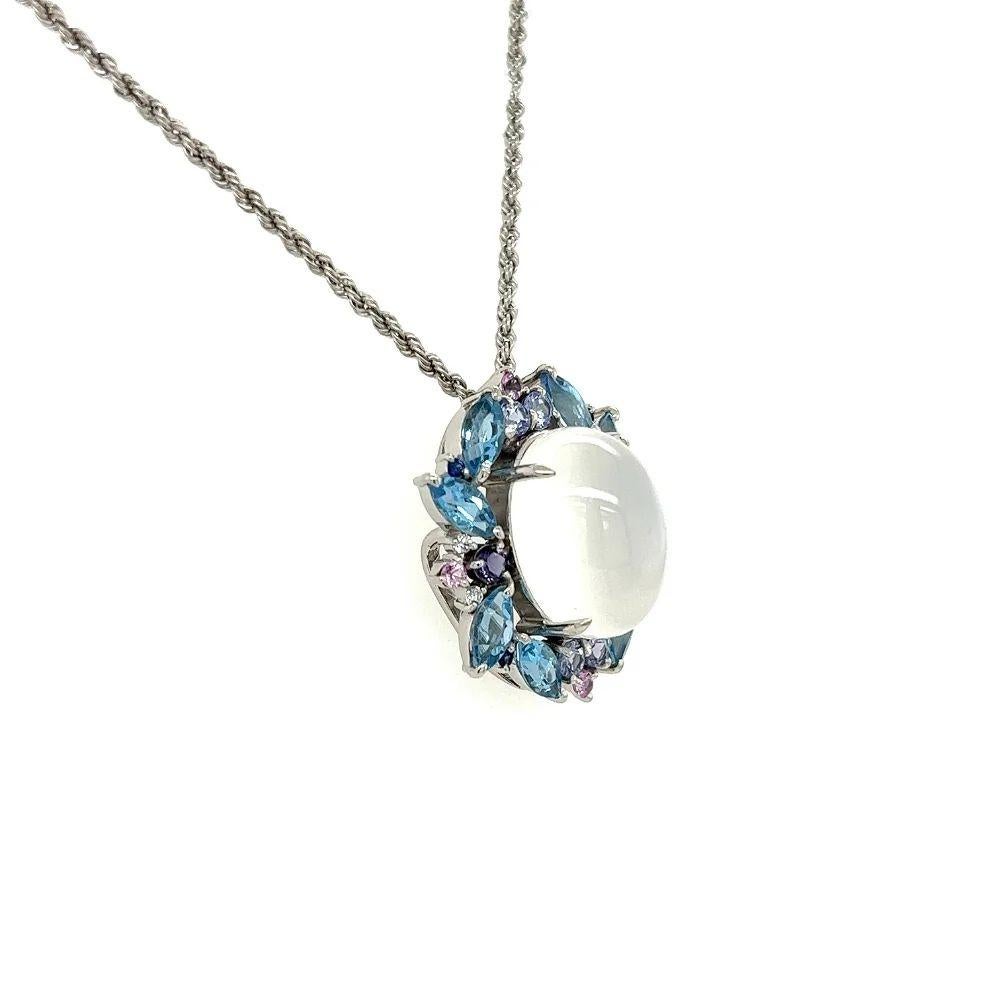 Simply Beautiful! Elegant and finely detailed Moonstone and Multi Gemstone Pendant Necklace Centering a securely Hand set 9.51 Carat Moonstone and surrounded by Moonstone, Topaz, Sapphire, Tanzanite & Diamonds. Hand crafted in 18K White Gold.