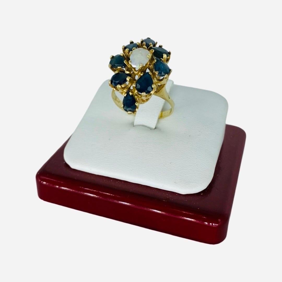 Vintage 9.56 Carat Blue Sapphires and Opal Center Cluster Cocktail Ring 14k Gold. Very impressive cocktail ring featuring 8 sapphires that are pear shaped weighting approx 8.40 carat in total weight and a center beautiful white opal stone weighting