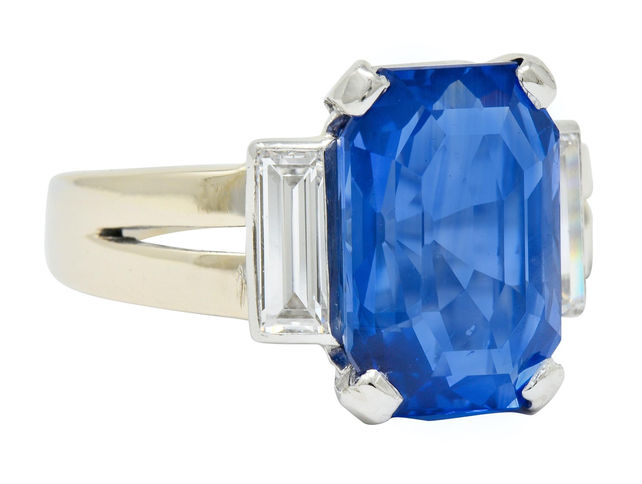 Centering a basket set emerald cut Ceylon sapphire weighing 9.00 carats

Transparent and cornflower blue in color with no indications of heat

Flanked by two bezel set rectangular step cut diamonds weighing approximately 0.72 carat, G/H color with